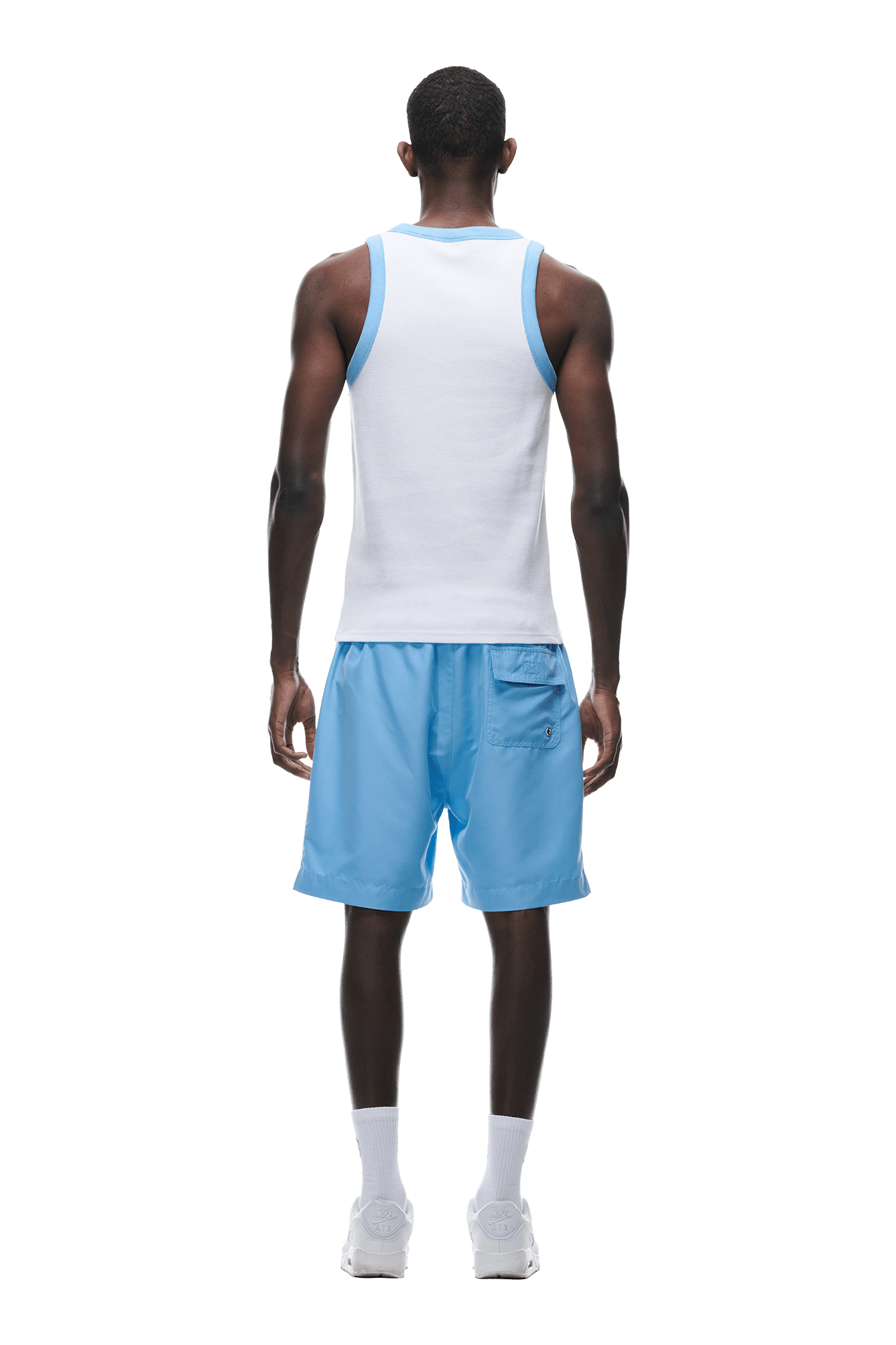 A man, seen from behind, wears the 6PM WAFFLE KNIT TANKTOP WHITE with light blue trim, paired with light blue shorts, white socks, and white sneakers against a plain white background.