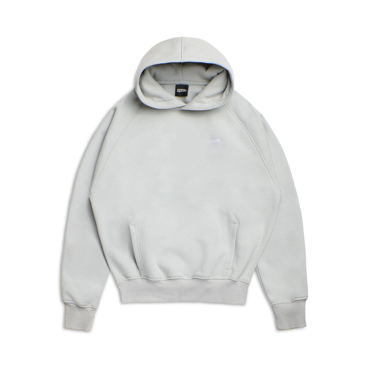 The HOODIE SMOKE GREY is a light gray, raglan-sleeved hoodie with a kangaroo pocket, long sleeves, and a small white chest logo, shown laid flat on a white background—ideal for everyday wear.