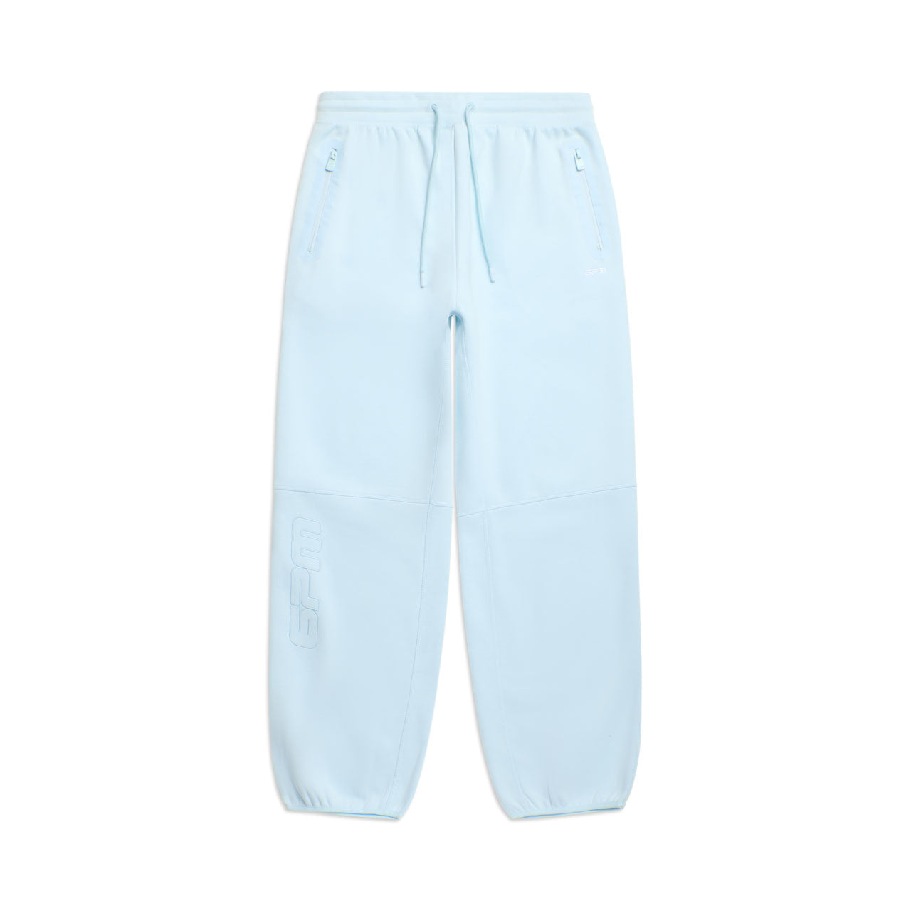 The 6PM WIDE ROADMAN PANTS ICE BLUE feature an elastic waistband, drawstring, zippered side pockets, and cuffed ankles. Subtle embossed text appears near the left knee. Pants are shown flat on a white background.