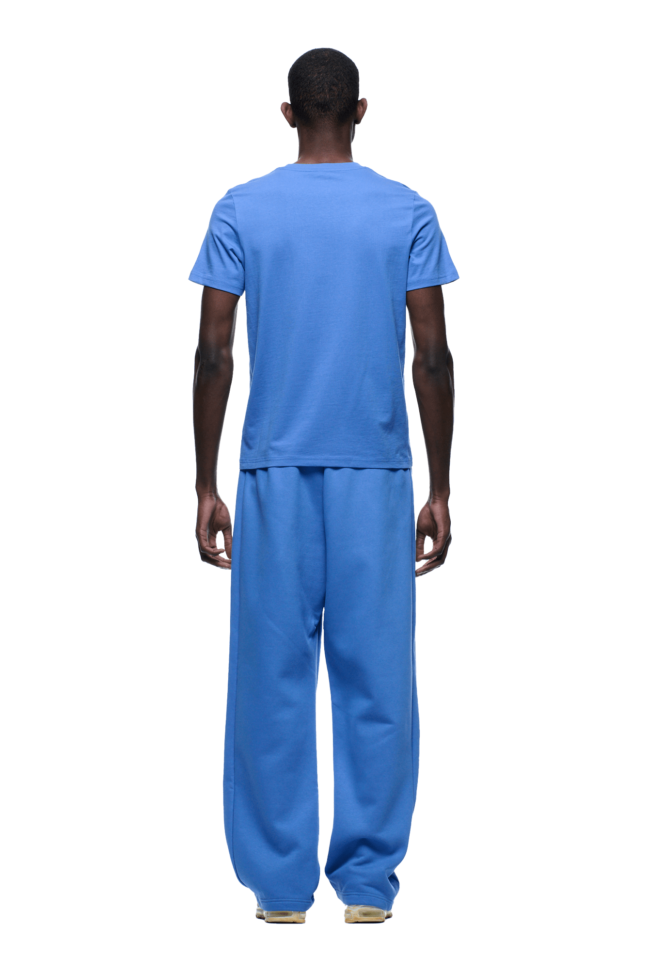 A person faces away, wearing the 6PM SLIM FIT T-SHIRT PERSIAN BLUE and loose pants, shown head to toe on a transparent background.