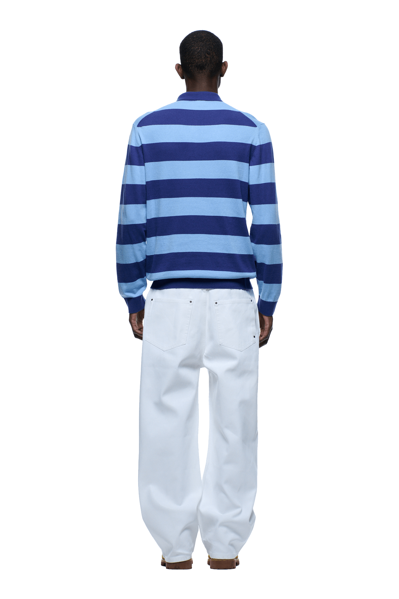 A person stands facing away, wearing the 6PM LS STRIPED POLO BLUE and loose-fitting white pants. The background is transparent.