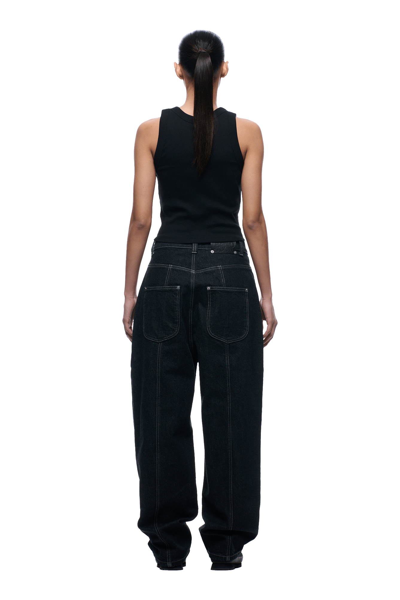 A woman with a long ponytail is seen from behind, wearing a black sleeveless top and 6PM TYPE 6 DENIM BLACK RAW jeans featuring prominent white stitching and large back pockets.
