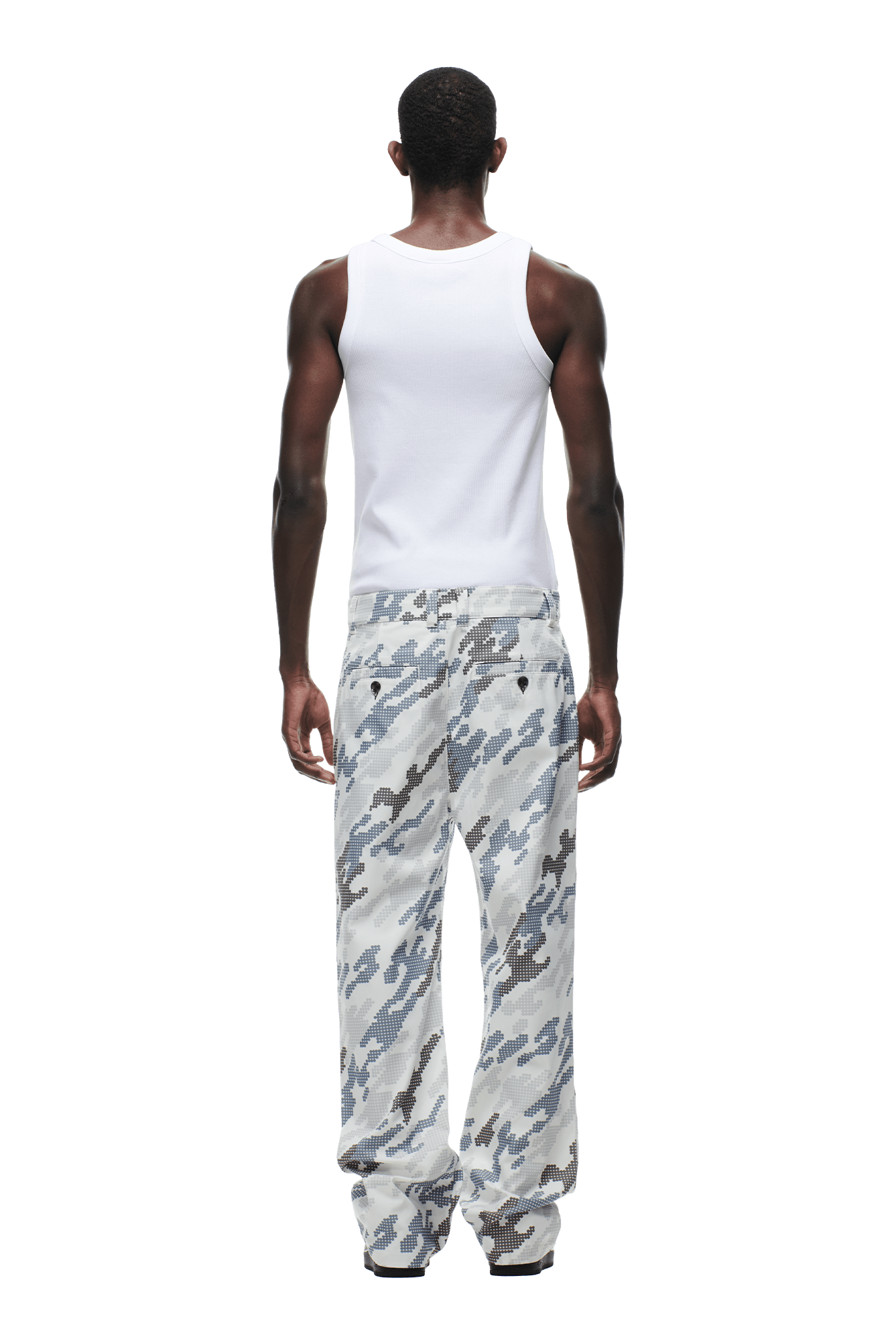 A person stands facing away, wearing a white tank top and 6PM DOT CAMO CHINO PANTS in loose gray camouflage. The background is transparent.