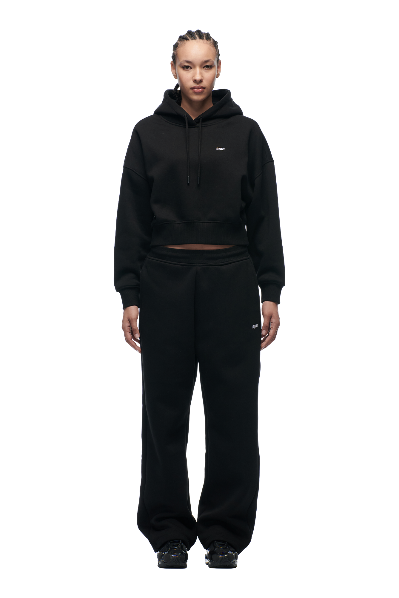 A woman faces forward on a white background, wearing the 6PM WMNS Cropped Hoodie in black, paired with matching black wide-leg sweatpants and black sneakers.