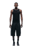 A man faces forward in a 6PM TANKTOP BLACK/WHITE with loose knee-length black shorts, black socks, and black shoes against a plain background.