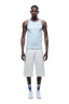 A man faces forward on a plain background, wearing the 6PM TANKTOP BABY BLUE/WHITE, white knee-length shorts, blue and red striped socks, and white sneakers.