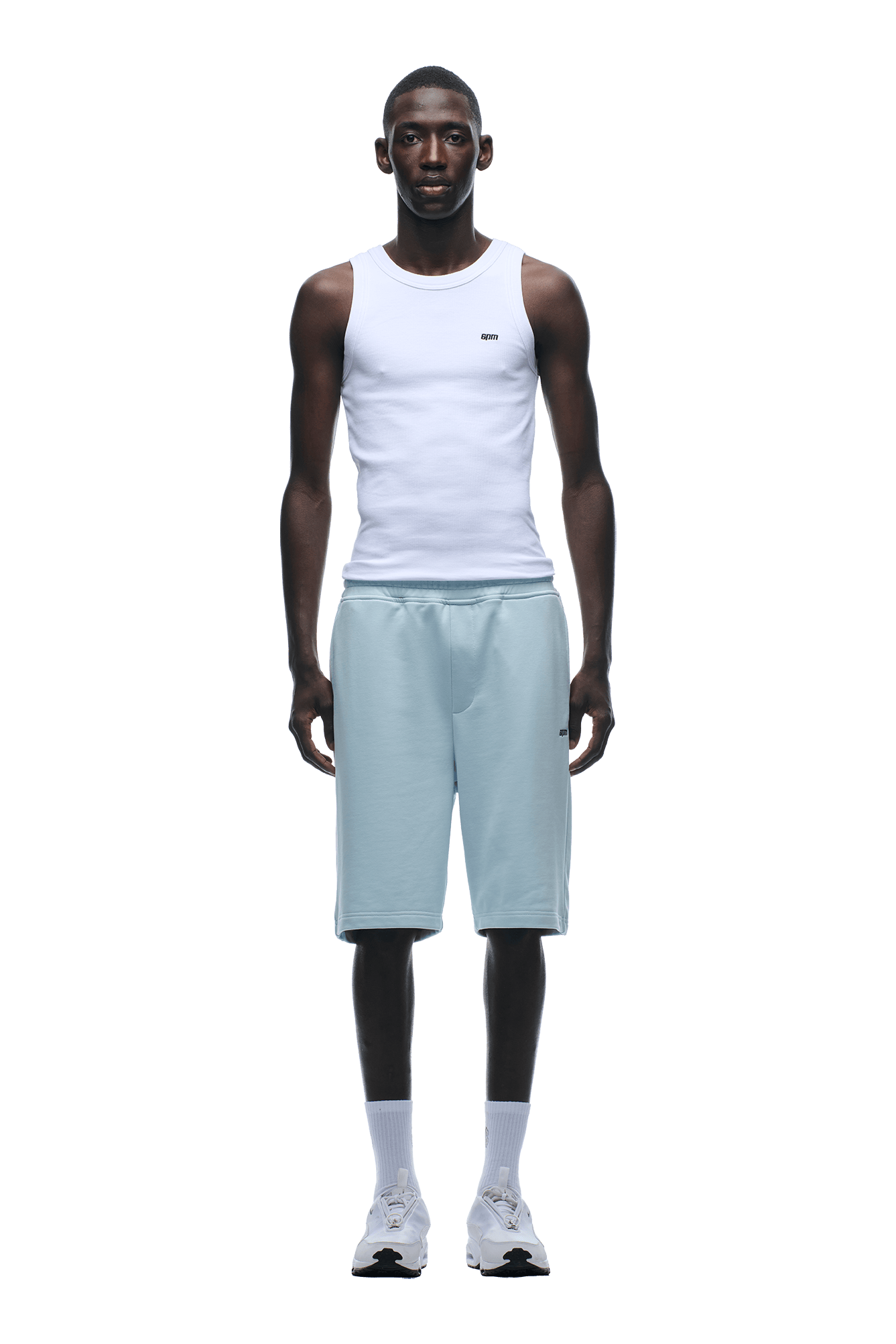 A man faces forward in a white sleeveless tank top and 6PM+ SHORTS ICE BLUE with drawstring waist, paired with white crew socks and sneakers. The image has a transparent background.