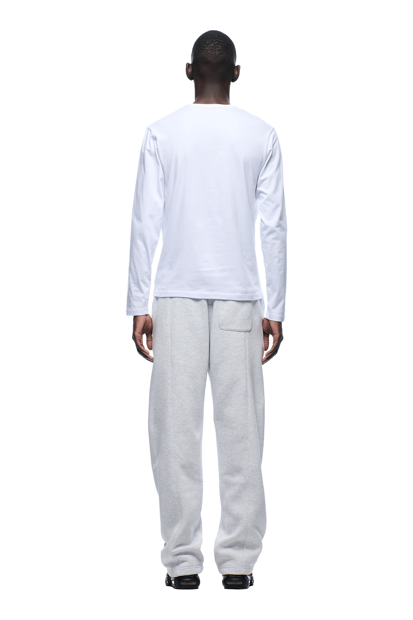 A person is facing away, dressed in a 6PM SLIM FIT LONGSLEEVE WHITE shirt and loose light gray sweatpants, against a white background.
