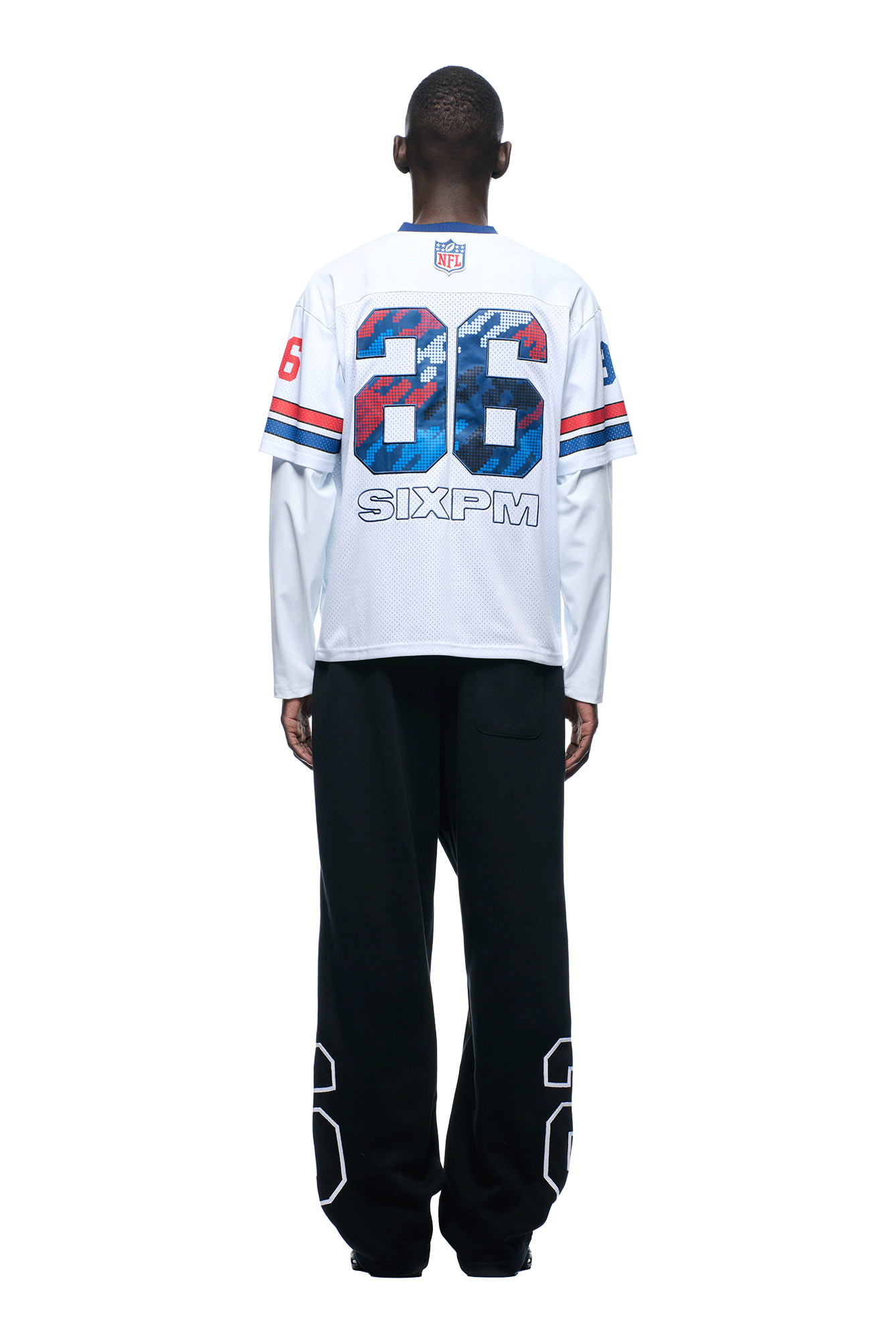 A person faces away, wearing the NFL LAYERED MESH LONGSLEEVE WHITE by 6PM, featuring the number 36, “SIXPM,” and NFL logo, paired with black pants displaying 36 on the lower legs. Background is plain white.