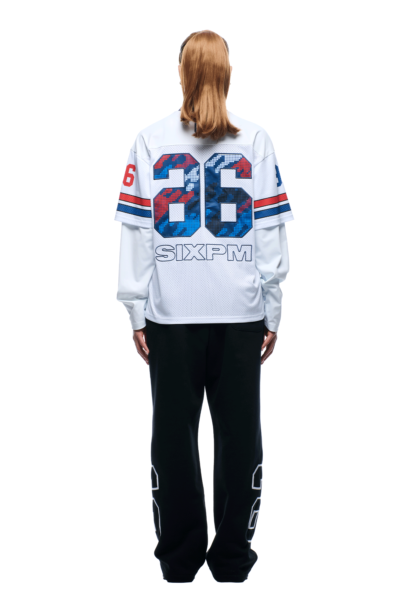A person with straight, light brown hair faces away, wearing the 6PM NFL Layered Mesh Longsleeve White jersey with blue and red stripes and the number 36, paired with black pants featuring white accents on the legs.