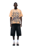 A man faces forward wearing the CAMO JERSEY BURRO by 6PM with number 26, black wide knee-length shorts, white socks, and sneakers. The background is transparent.