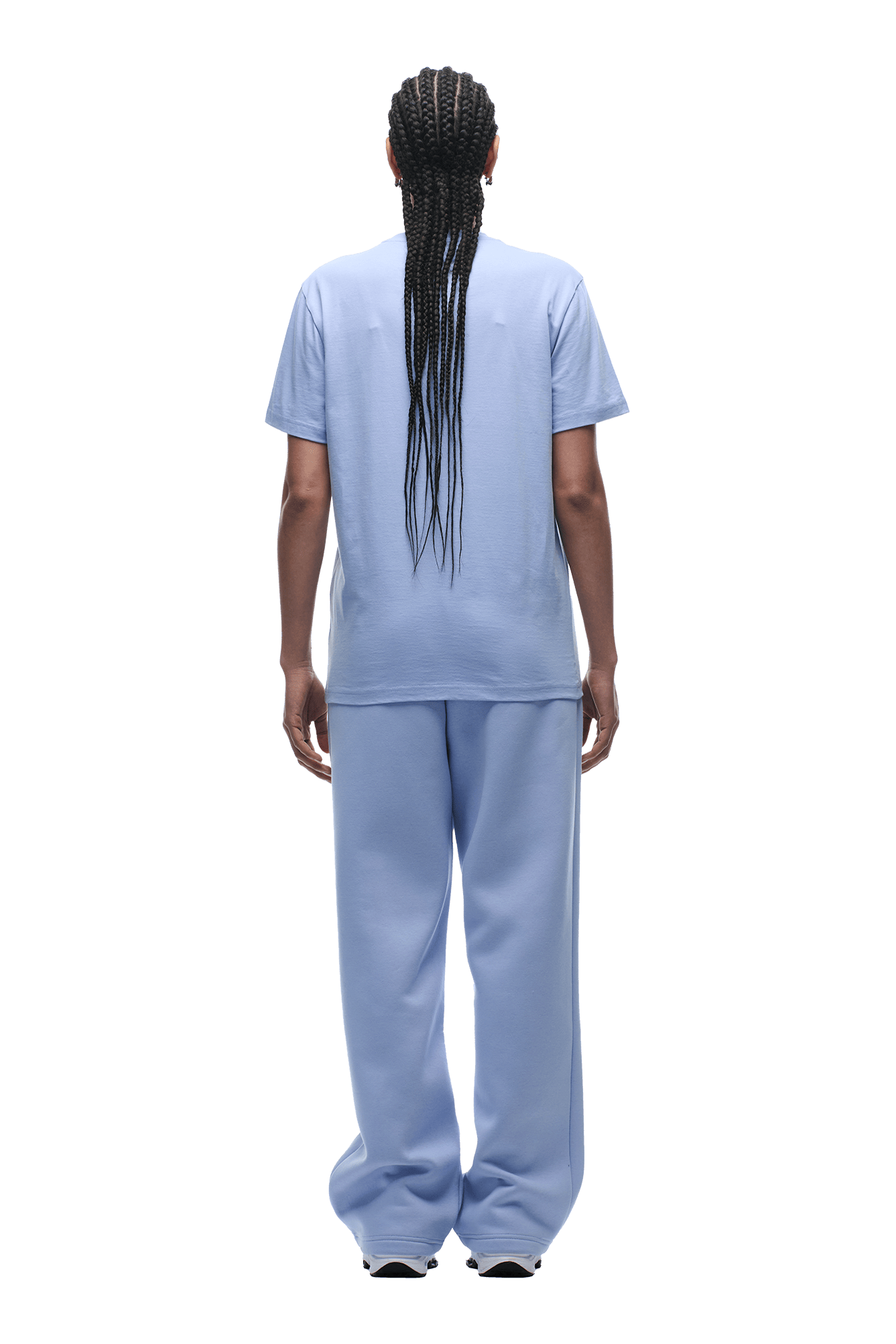 A person with long braids faces away, showing off the 6PM T-SHIRT REGULAR FIT SOFT VIOLET paired with loose-fitting matching pants. Transparent background.