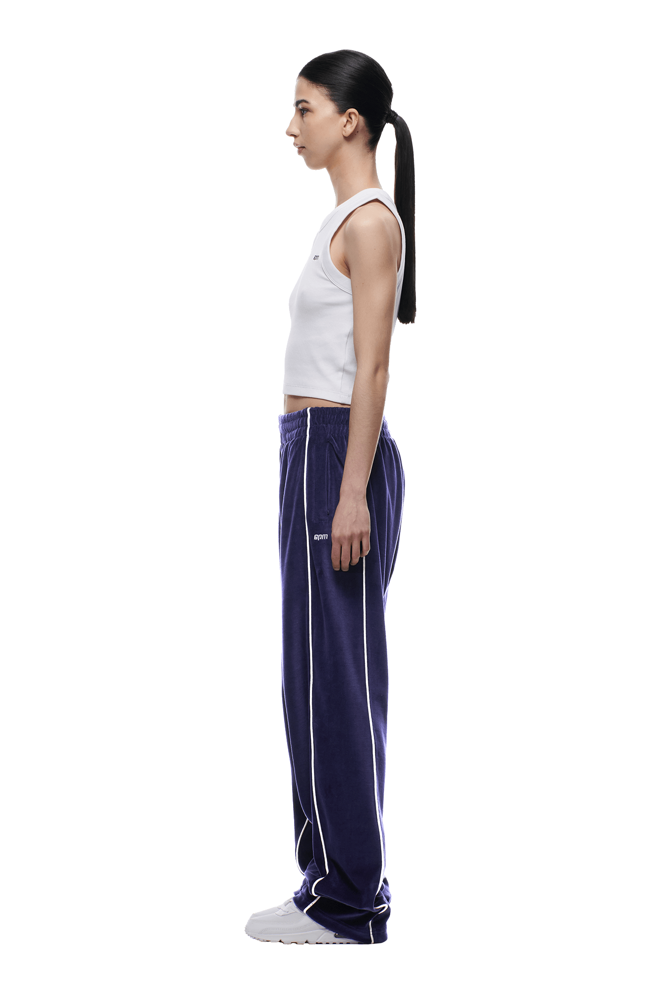 A woman wearing 6PM VELOURS TRACK PANT ORBIT BLUE and a white tank top.