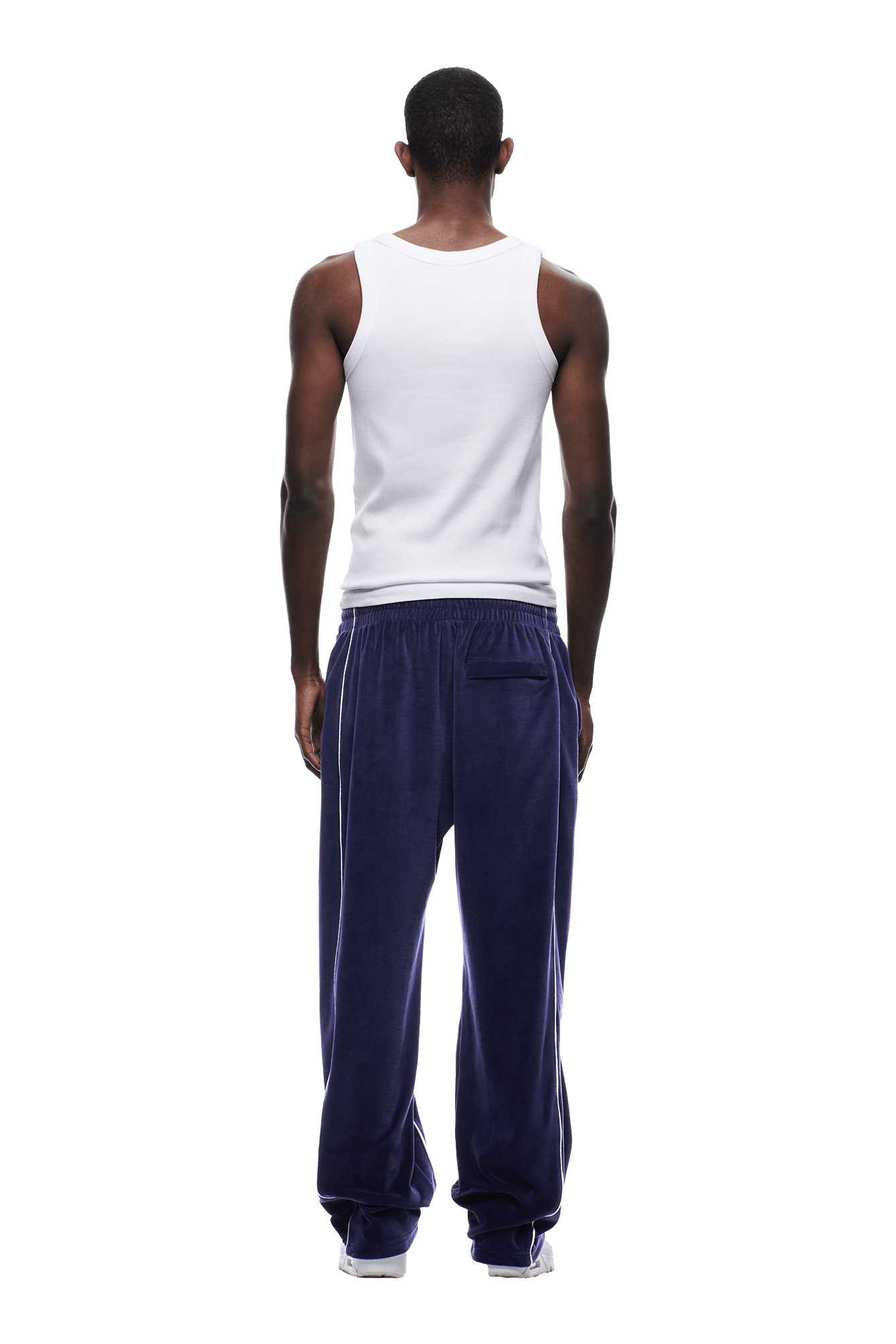A person faces away, wearing a white sleeveless shirt and 6PM's VELOURS TRACK PANT ORBIT BLUE, against a plain white background.