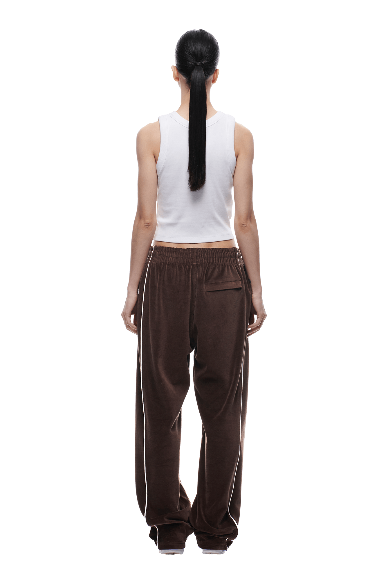 A woman wears 6PM's VELOURS TRACK PANT in chocolate brown and a white tank top.