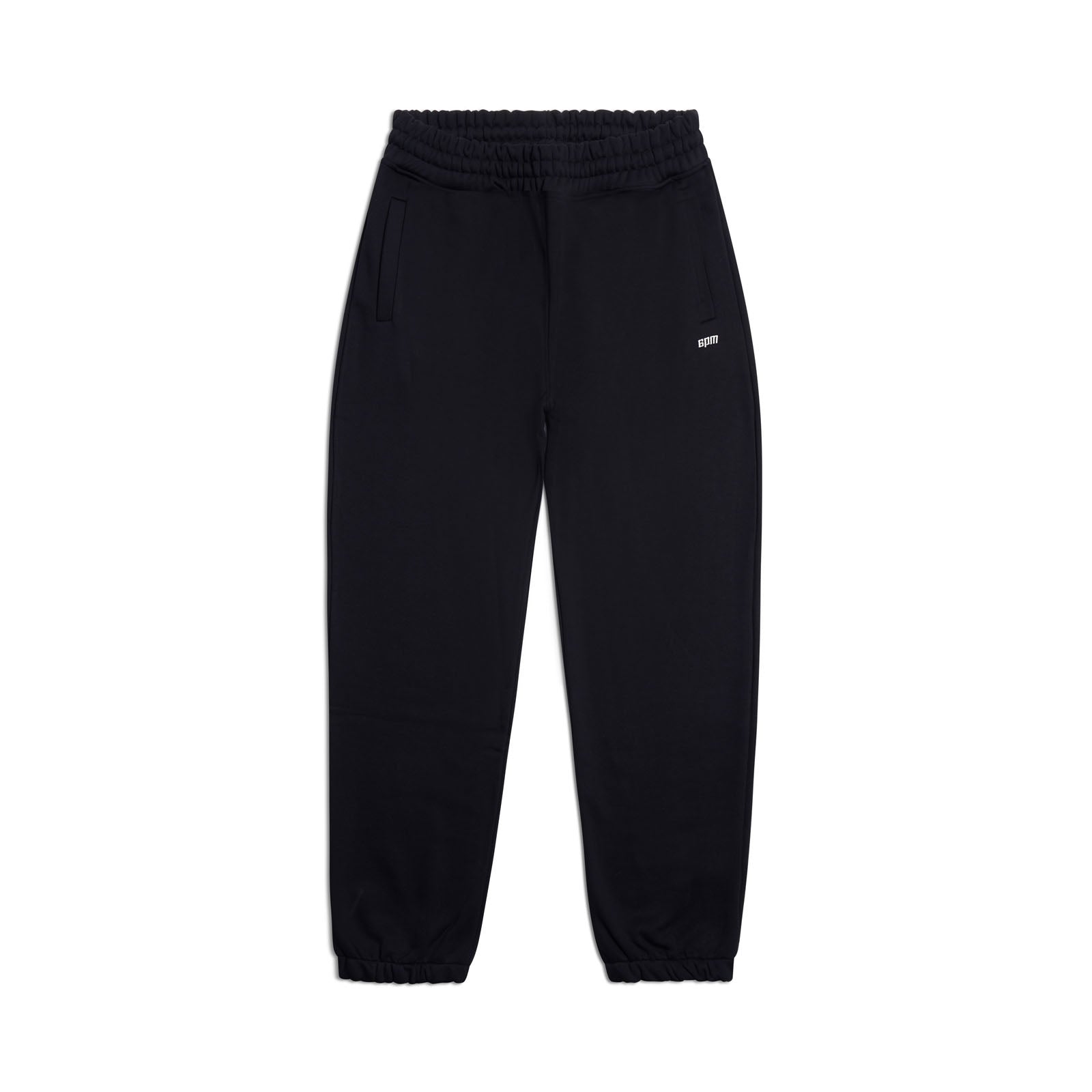The CUFF JOGGER BLACK features an elastic waistband, cuffed leg openings, two side pockets, and a small white logo on the upper left. These classic black sweatpants are displayed laid flat on a white background.