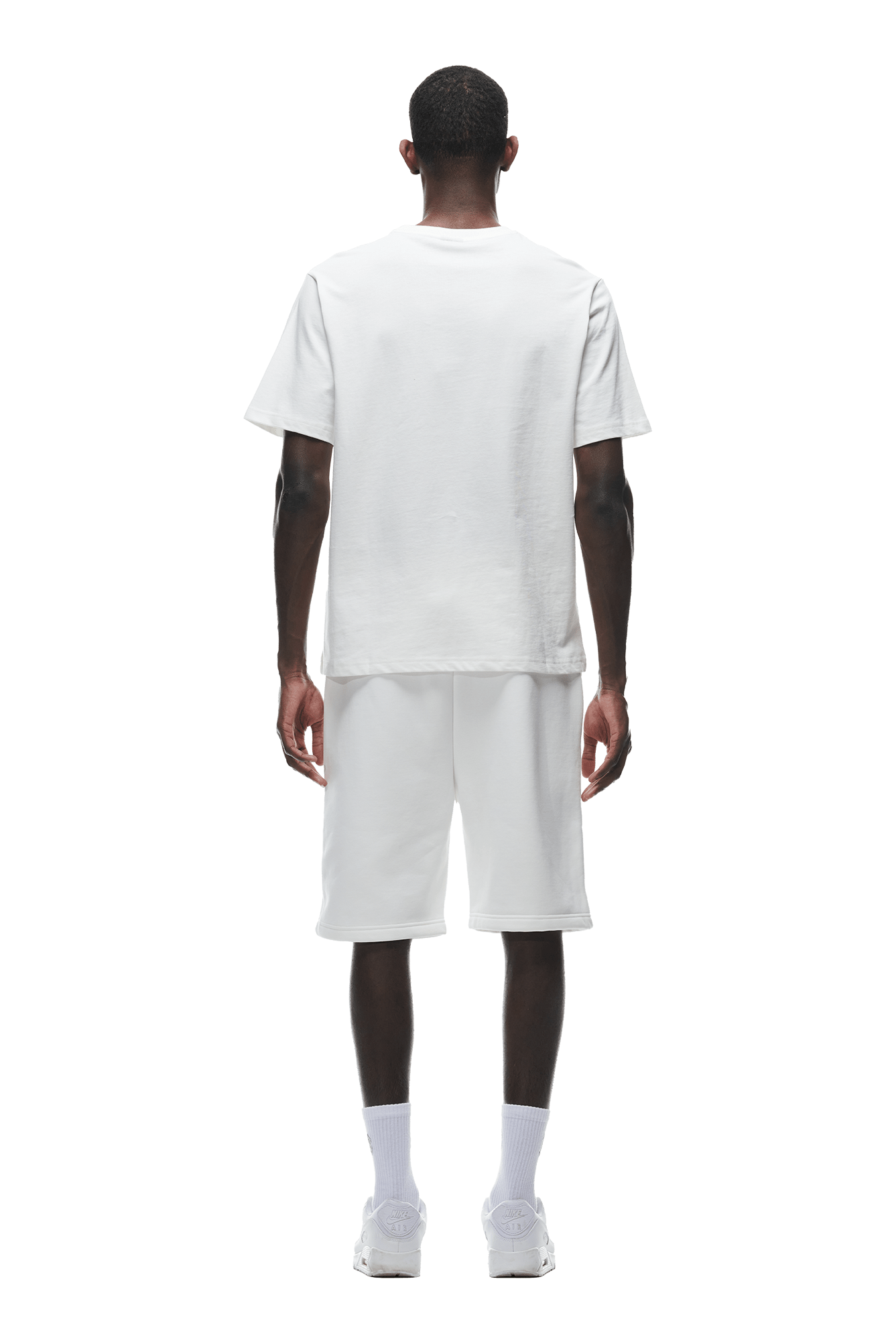 A person faces away wearing the 6PM T-SHIRT COCONUT WHITE, paired with white knee-length shorts, white socks, and white sneakers against a plain background.