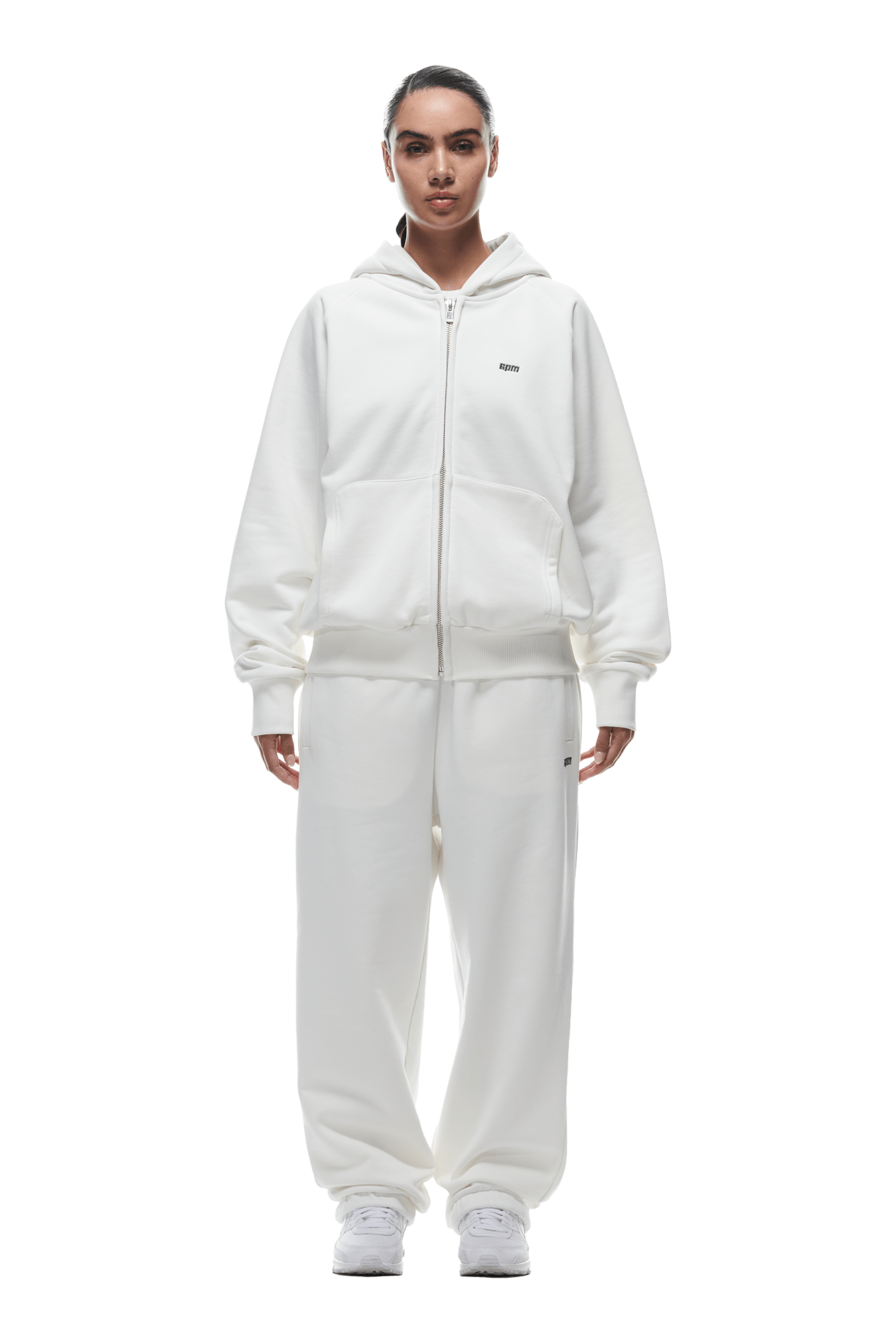 A person faces forward in a 6PM ZIP HOODIE COCONUT WHITE, paired with matching sweatpants and white sneakers. The loose fit and minimal branding create a clean, everyday look on a transparent background.
