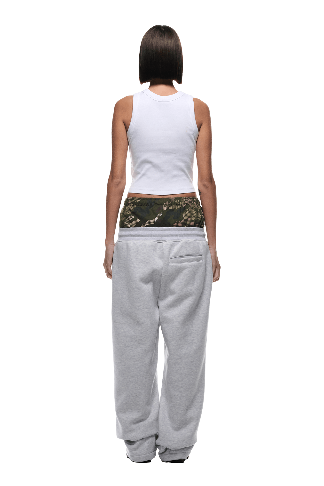 A person with straight, shoulder-length dark hair is seen from behind wearing a white sleeveless top, 6PM BOXERS OPEN LEG JOGGER GREY sweatpants, and camouflage-patterned underwear visible above the waistband.