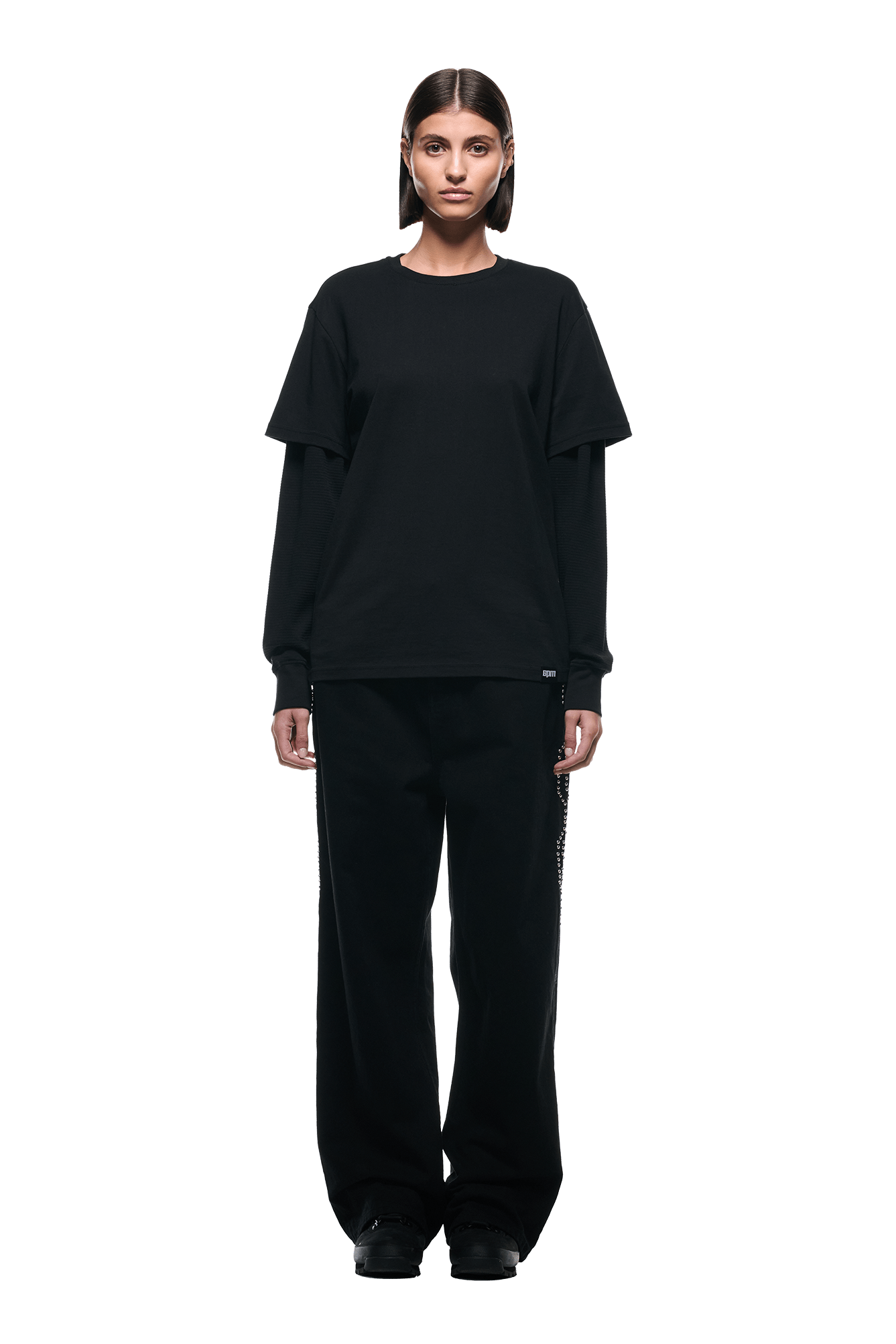 A person faces forward against a plain white background, wearing the 6PM LAYERED LONGSLEEVE BLACK with a short-sleeve black tee and baggy black pants.