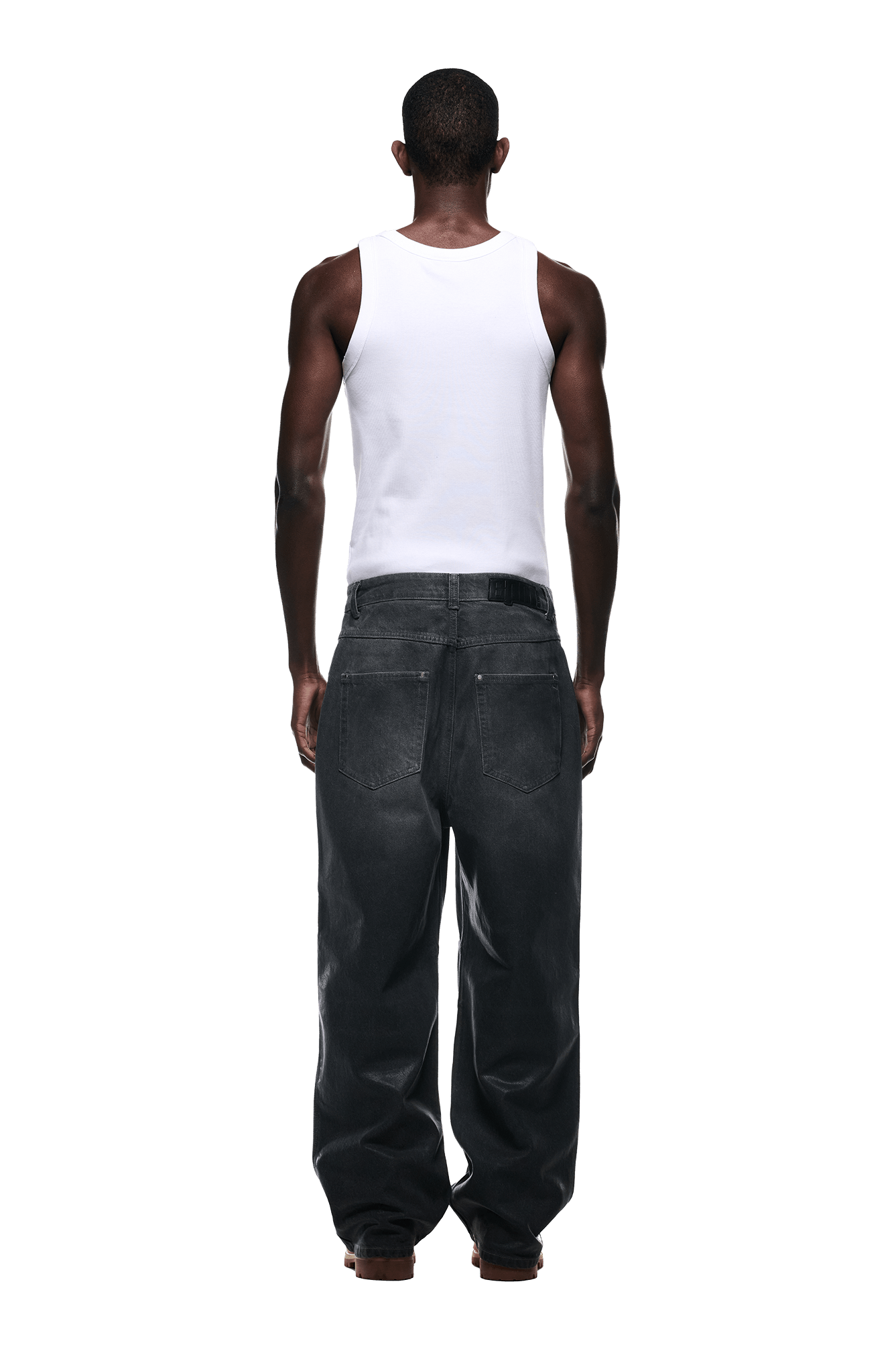 A person faces away, wearing a white sleeveless shirt and 6PM’s WAX COATED DENIM GREY jeans against a plain light background.