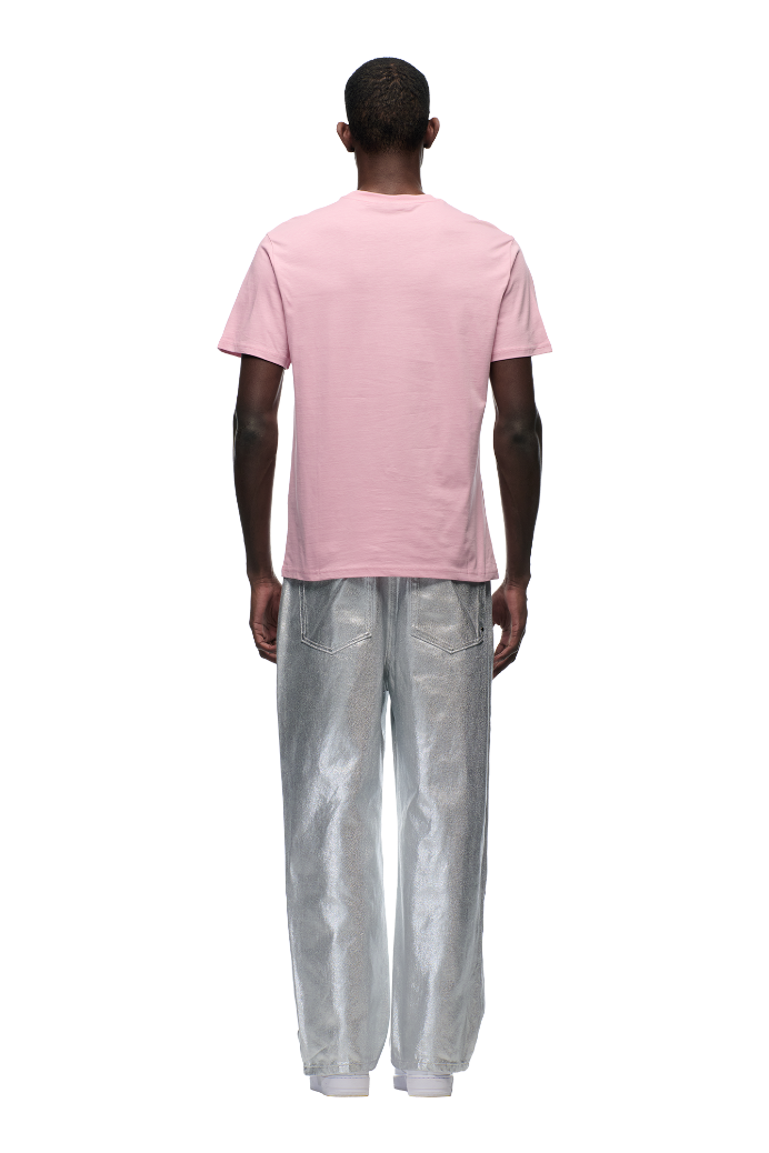 Someone stands with their back to the camera wearing the 6PM CLEAN EDGE WAVE T-SHIRT PINK, shiny silver pants, and white shoes, set against a plain light background.