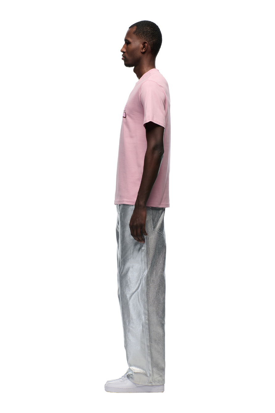 A man in profile against a white background wears the 6PM CLEAN EDGE WAVE T-SHIRT PINK, metallic silver pants, and white shoes.
