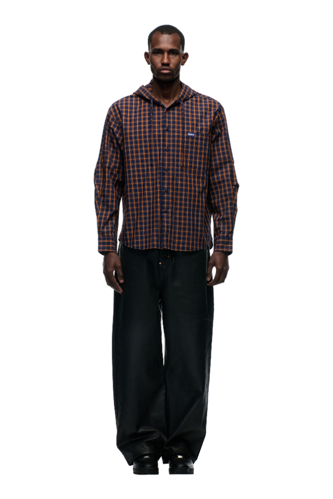 A man stands facing forward, wearing the 6PM HOODED DRESS SHIRT in blue, orange, and black, paired with wide-leg black pants and black shoes against a plain white background.