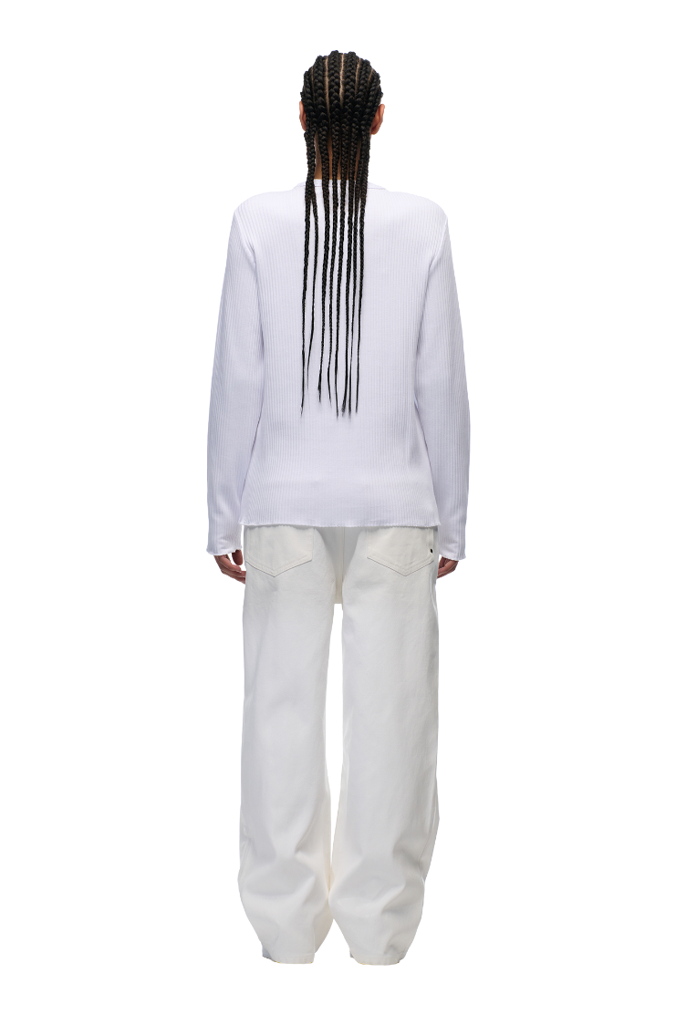 Model with long braids wears the 6PM+ RIBBED LS WHITE top by 6PM and loose white pants, shown from the back against a plain white background.