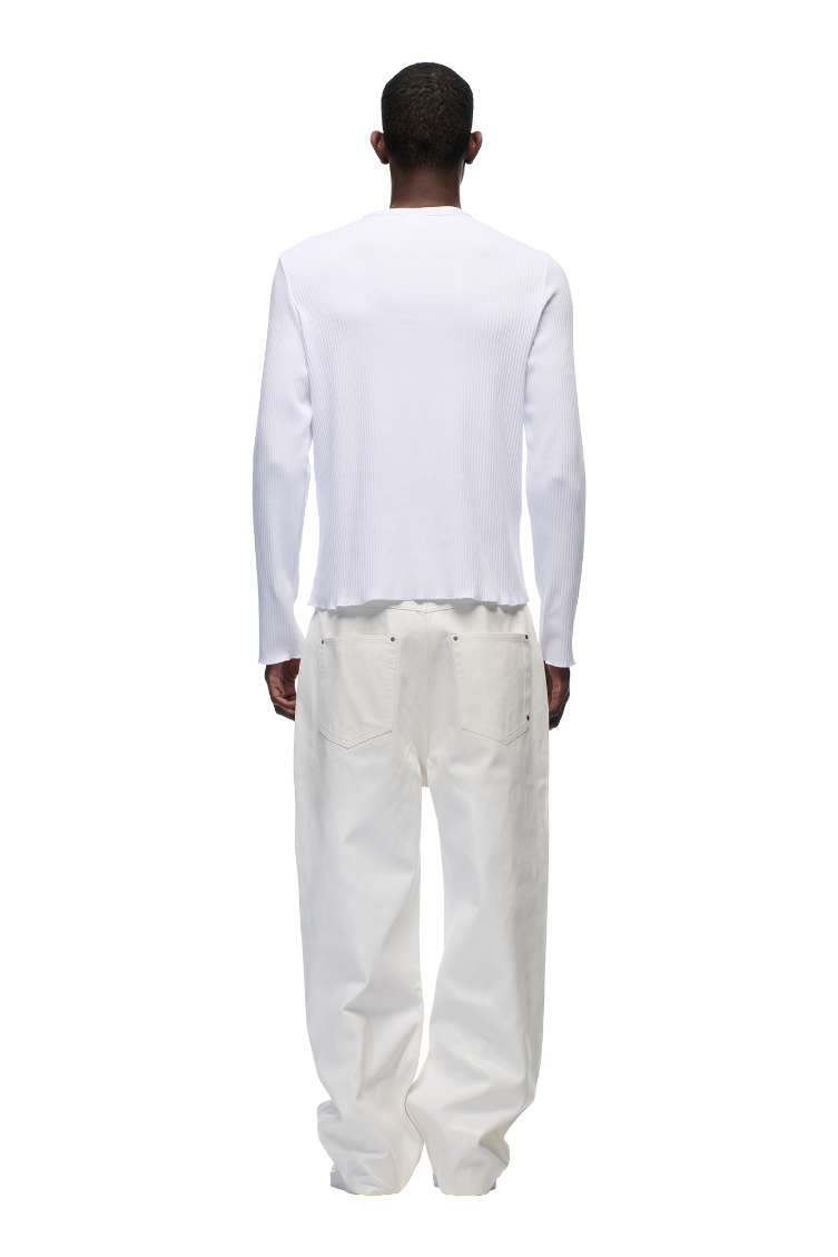 A man faces away from the camera, wearing the 6PM 6PM+ RIBBED LS WHITE top and matching white pants with a tonal flag label, set against a plain light background.