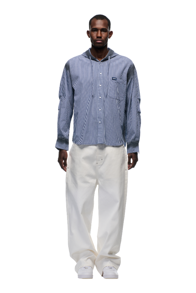 A man faces forward wearing the 6PM HOODED DRESS SHIRT DEEP SEA BLUE/WHITE, paired with white wide-leg pants and white sneakers, set against a plain light background.