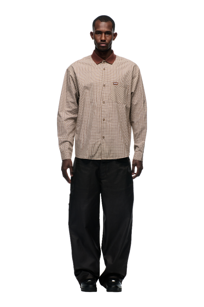 A man faces forward against a white background, wearing the 6PM POLO COLLAR SHIRT COCOA BROWN with horn buttons and a ribbed collar, paired with loose-fitting black pants.