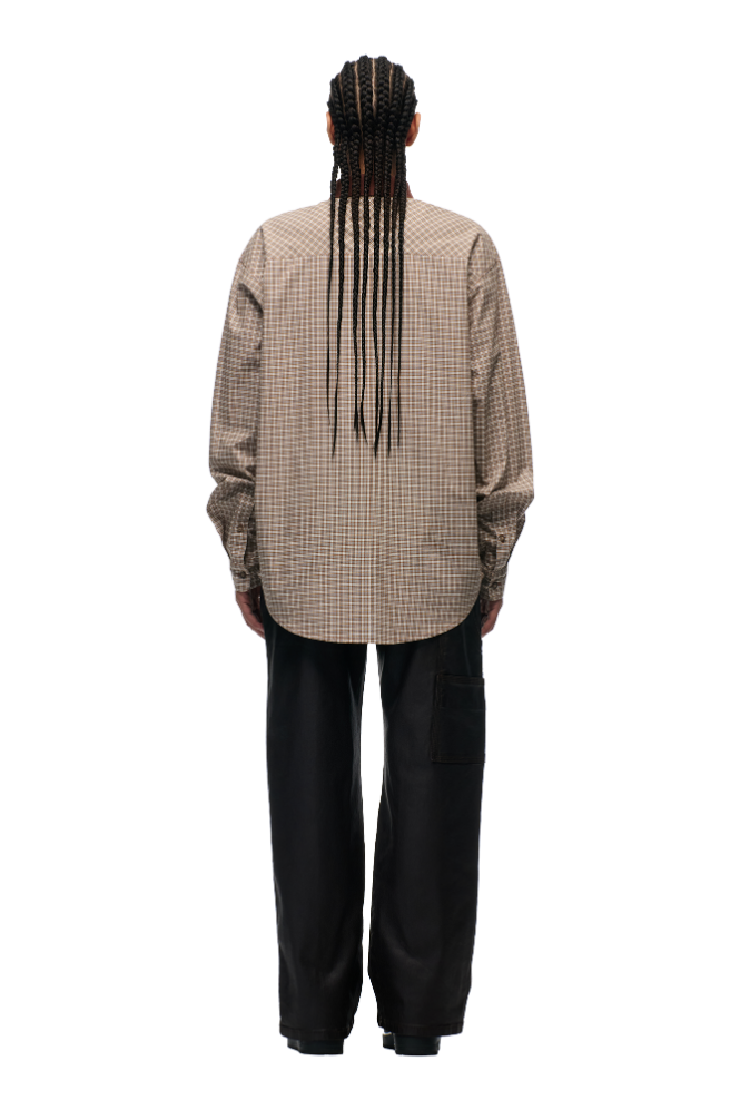 Person with long braids wearing a POLO COLLAR SHIRT COCOA BROWN by 6PM and loose black pants, standing facing away from the camera against a plain white background.