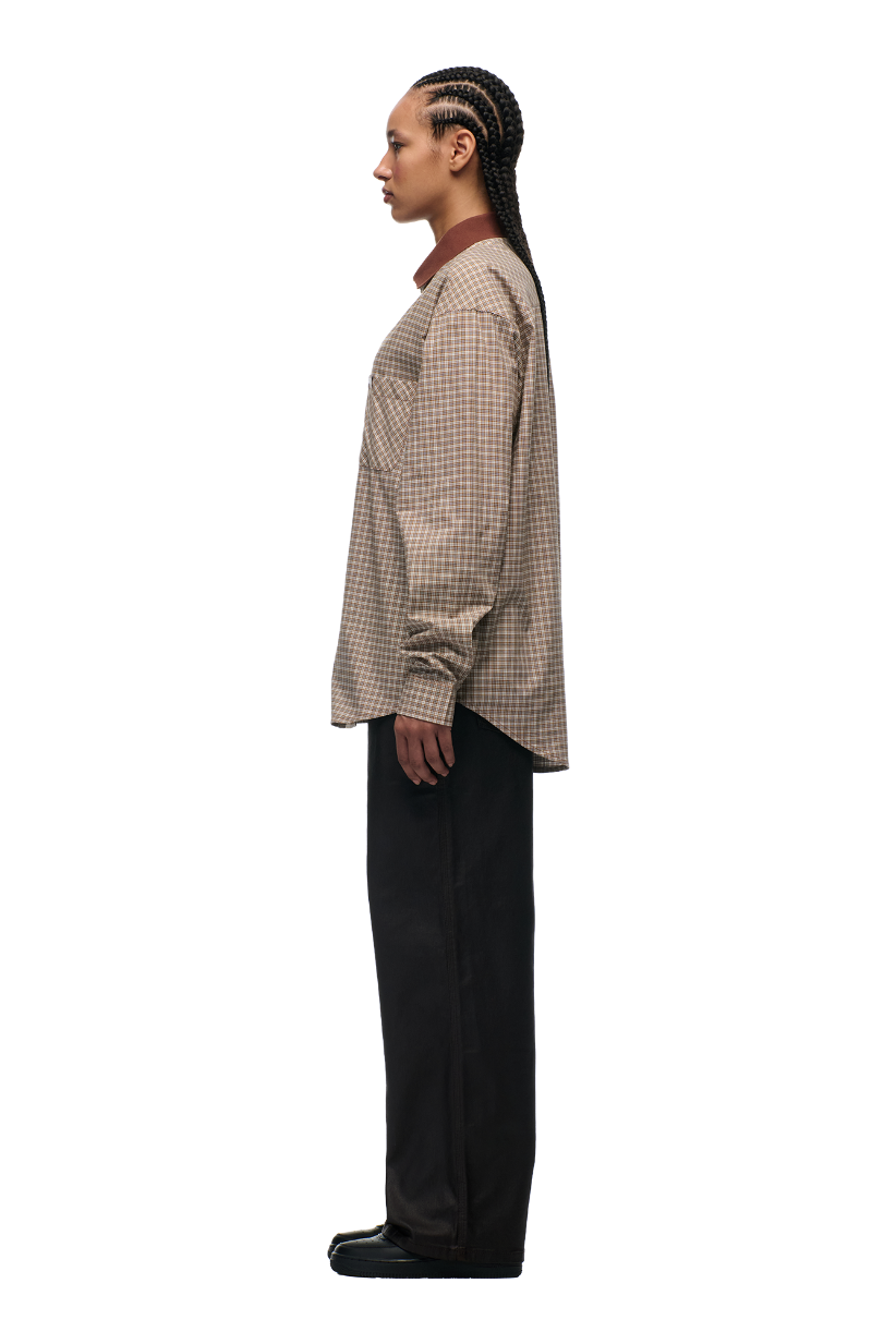 A person with long braids stands in profile against a white background, wearing the 6PM POLO COLLAR SHIRT COCOA BROWN, paired with dark wide-leg pants and black shoes.
