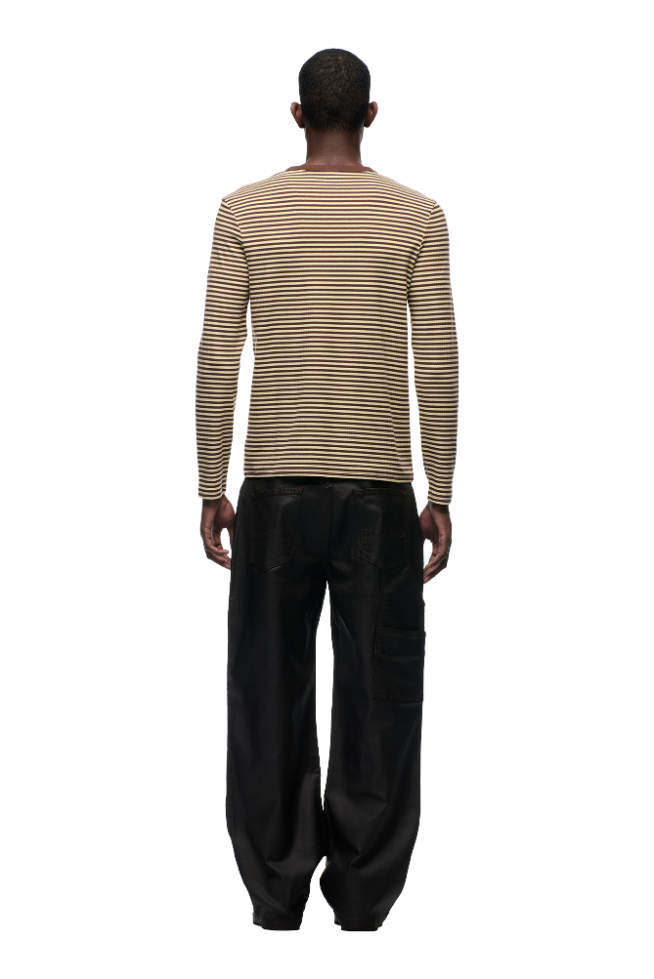A person faces away from the camera, wearing the 6PM STRIPED RIBBED LS DARK HAZELNUT top and loose black pants, set against a plain white background.