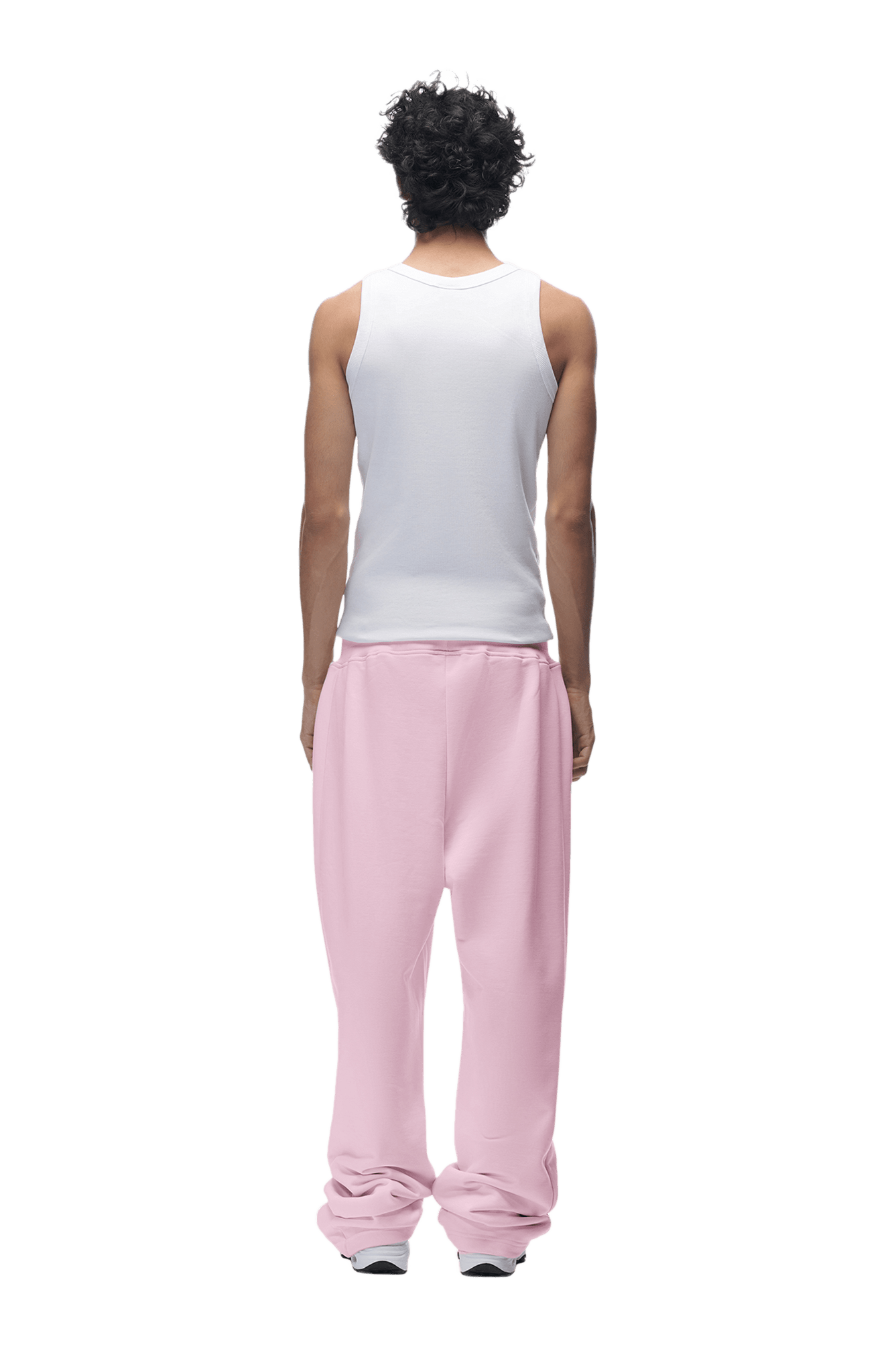 A person with curly hair, seen from behind, wears a white sleeveless shirt and 6PM OPEN LEG JOGGER BABY PINK pants, standing against a transparent background.
