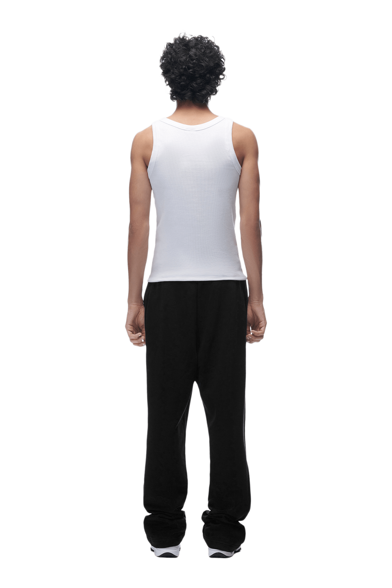 A person with curly hair, in a white sleeveless shirt and the OPEN LEG JOGGER BLACK, stands facing away from the camera against a transparent background.