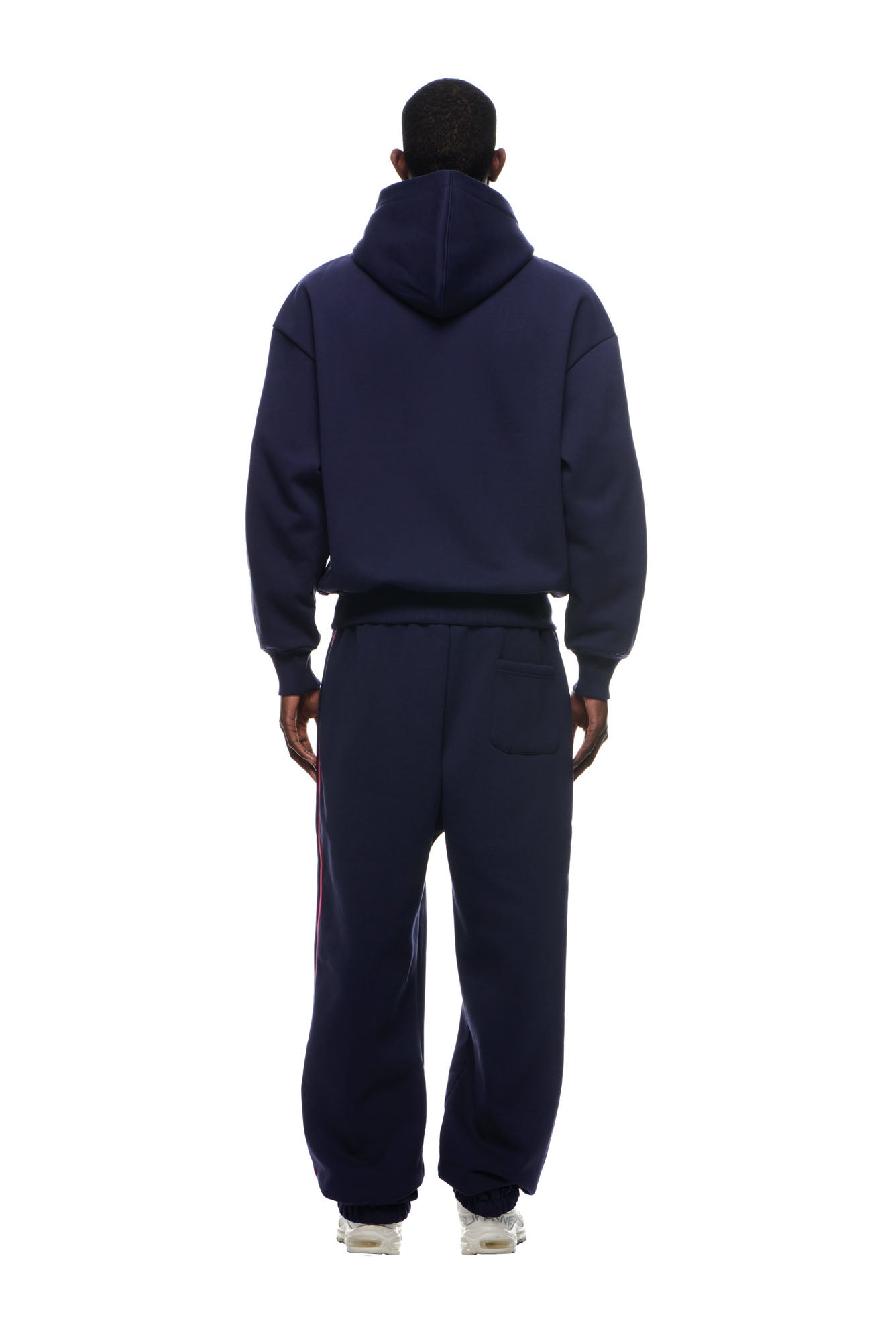 A person faces away from the camera wearing the 6PM RECORDS HOODIE DEEP BLUE with matching sweatpants and white sneakers, set against a plain white background.