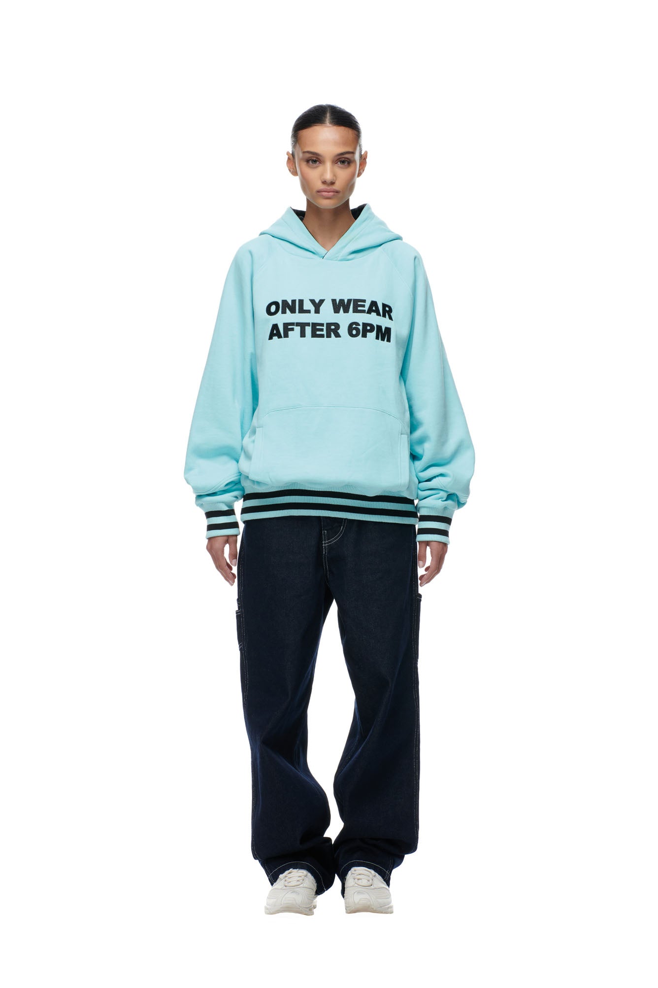 A woman wearing the 6PM ONLY WEAR REVERSIBLE HOODIE in black and turquoise.