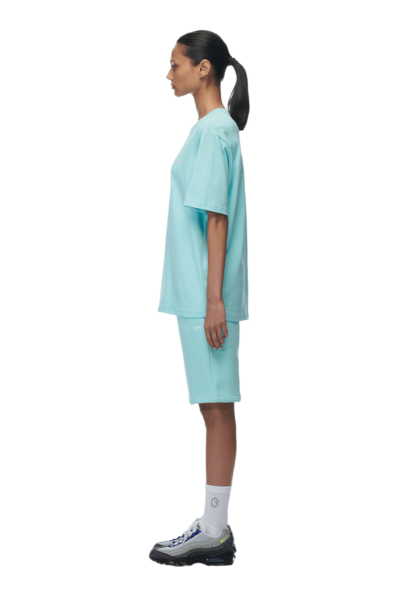 A woman wearing a 6PM T-SHIRT TURQUOISE with shorts.