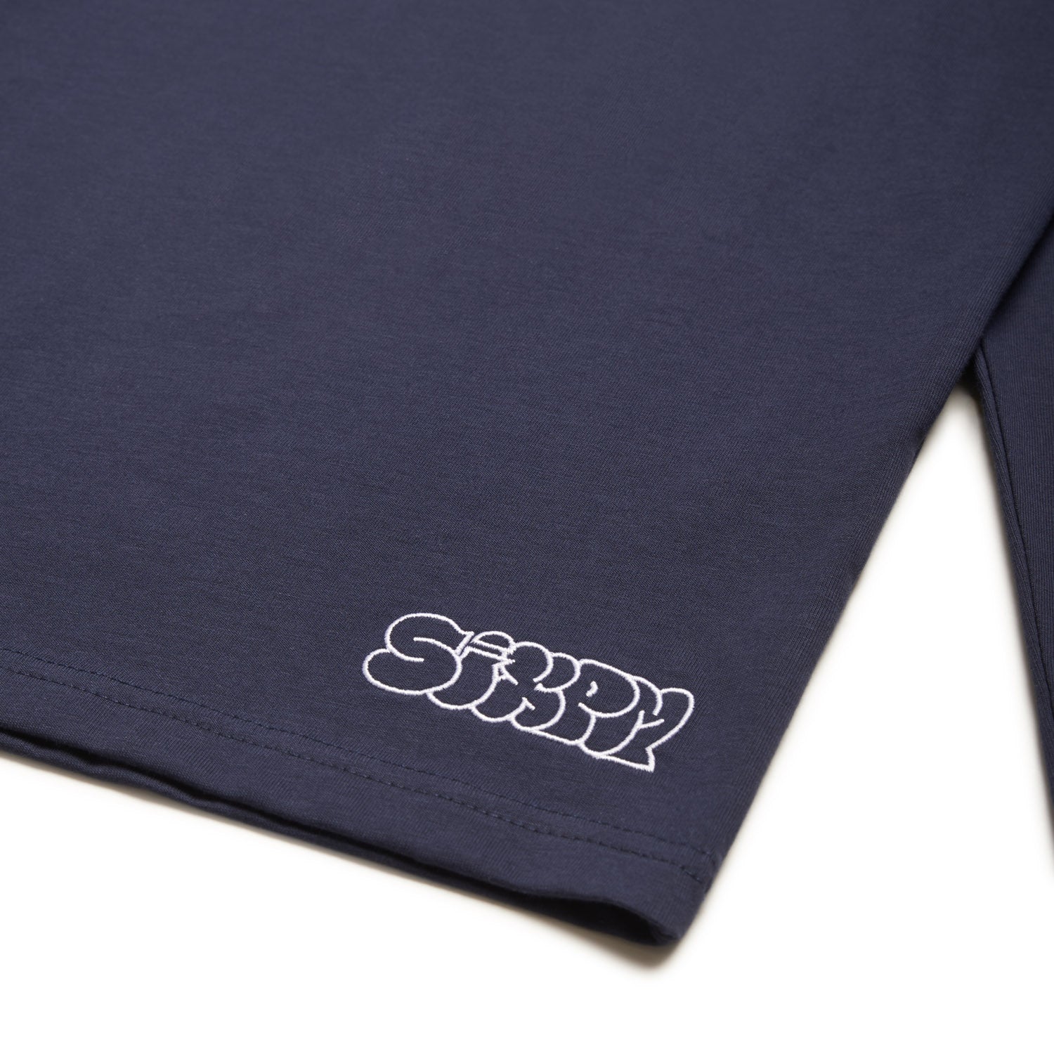 A midnight blue GRAFFITI RINGER LS T-shirt by 6PM featuring "SiXPM" in white bubble letters near the bottom hem.