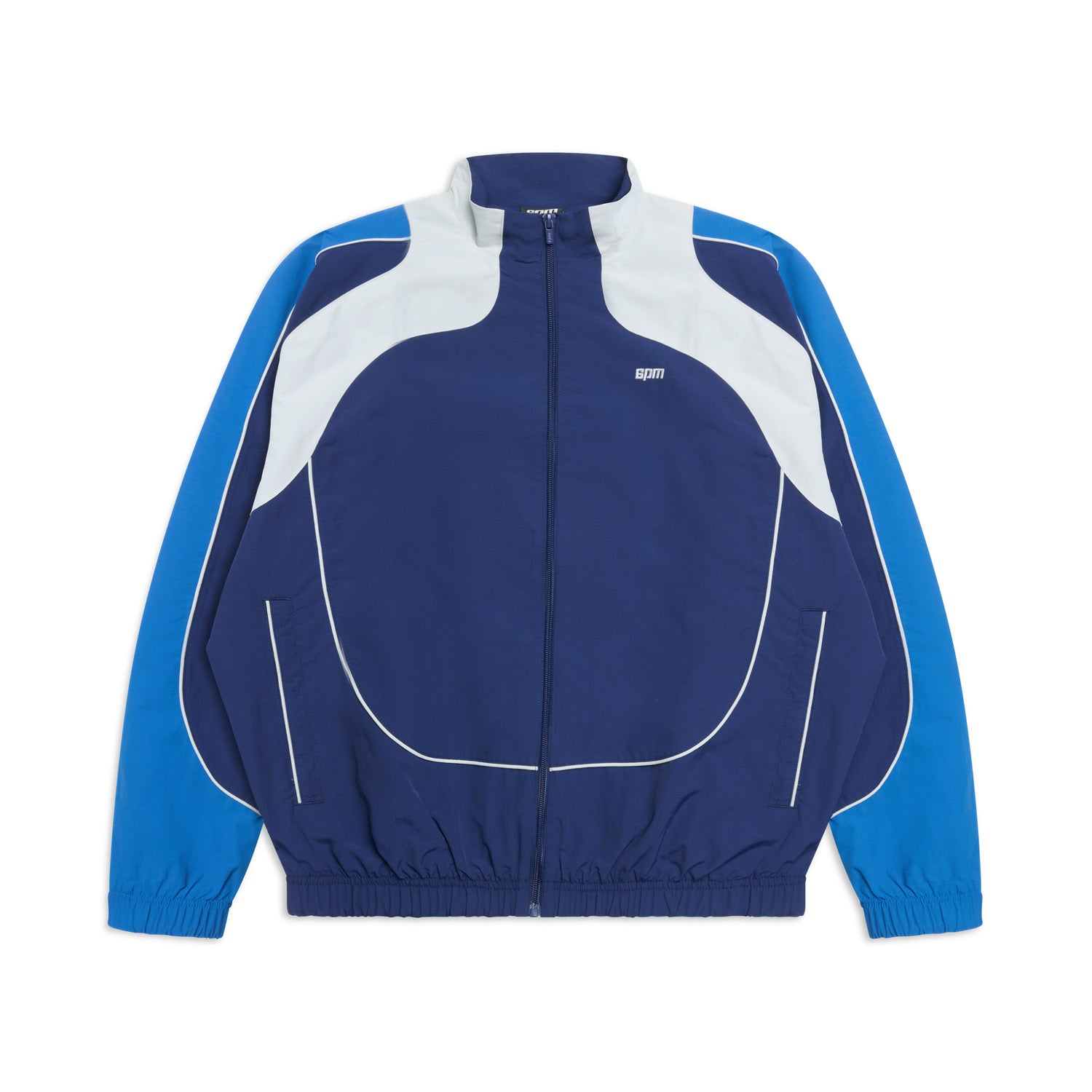 The 6PM EVERYDAY TRACK JACKET SHADOW BLUE is a blue and white track jacket with a front zipper, long sleeves, elastic cuffs and hem, curved white accents, and light blue panels on the shoulders and arms.