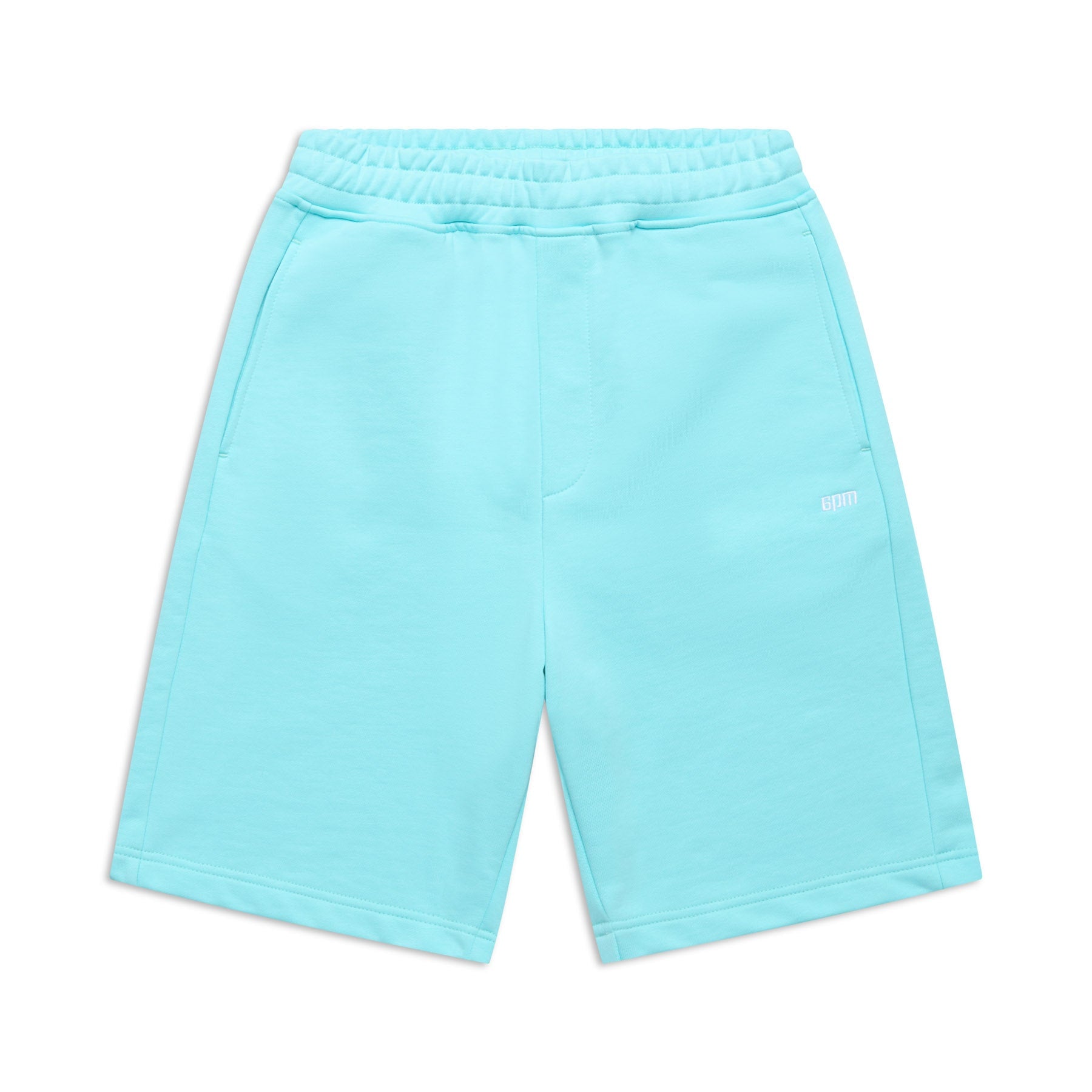 The 6PM+ SHORTS TURQUOISE by 6PM are light blue athletic shorts with a relaxed fit, elastic drawstring waist, side pockets, and a small white logo on one leg. Laid flat on white background, theyre perfect for lounging.