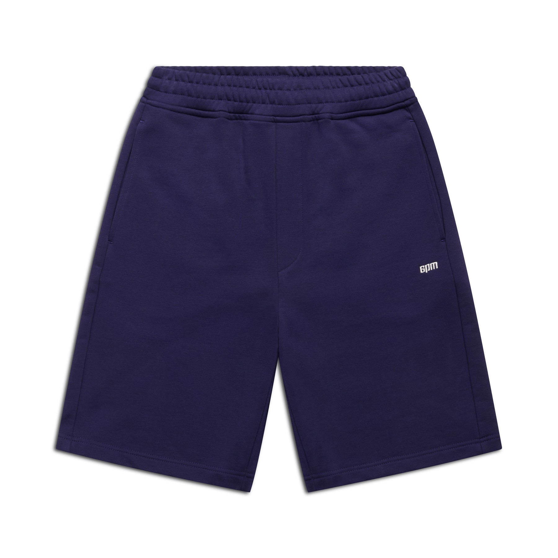 The 6PM+ SHORTS ORBIT BLUE by 6PM are dark blue athletic shorts featuring a relaxed fit, elastic waistband, side pockets, and a small white CDTM logo on the left thigh. Laid flat on a white background—perfect for lounging.