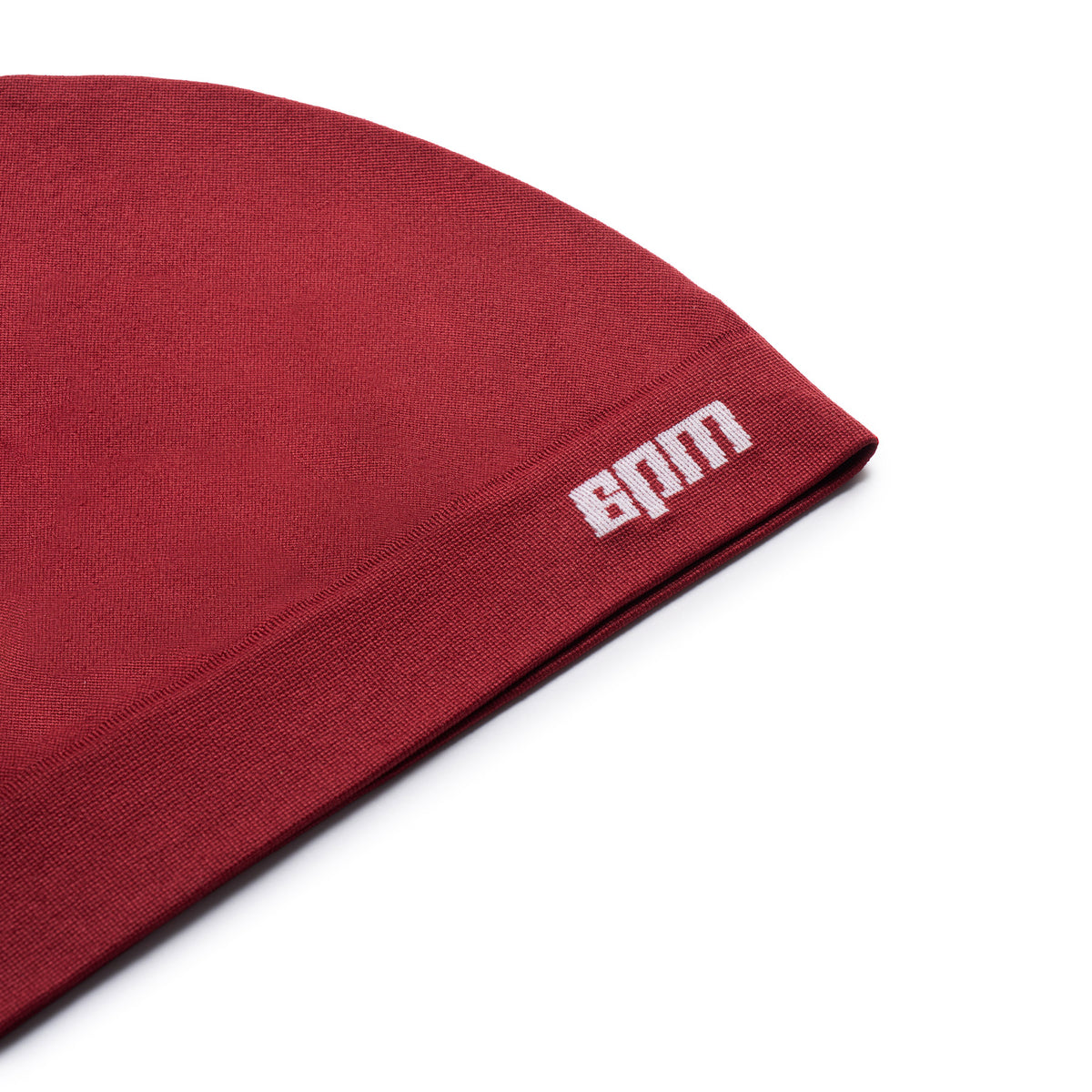 Close-up of the 6PM TECHNICAL LOGO BEANIE in wine red, featuring a white embroidered logo near the edge, shown against a white background.