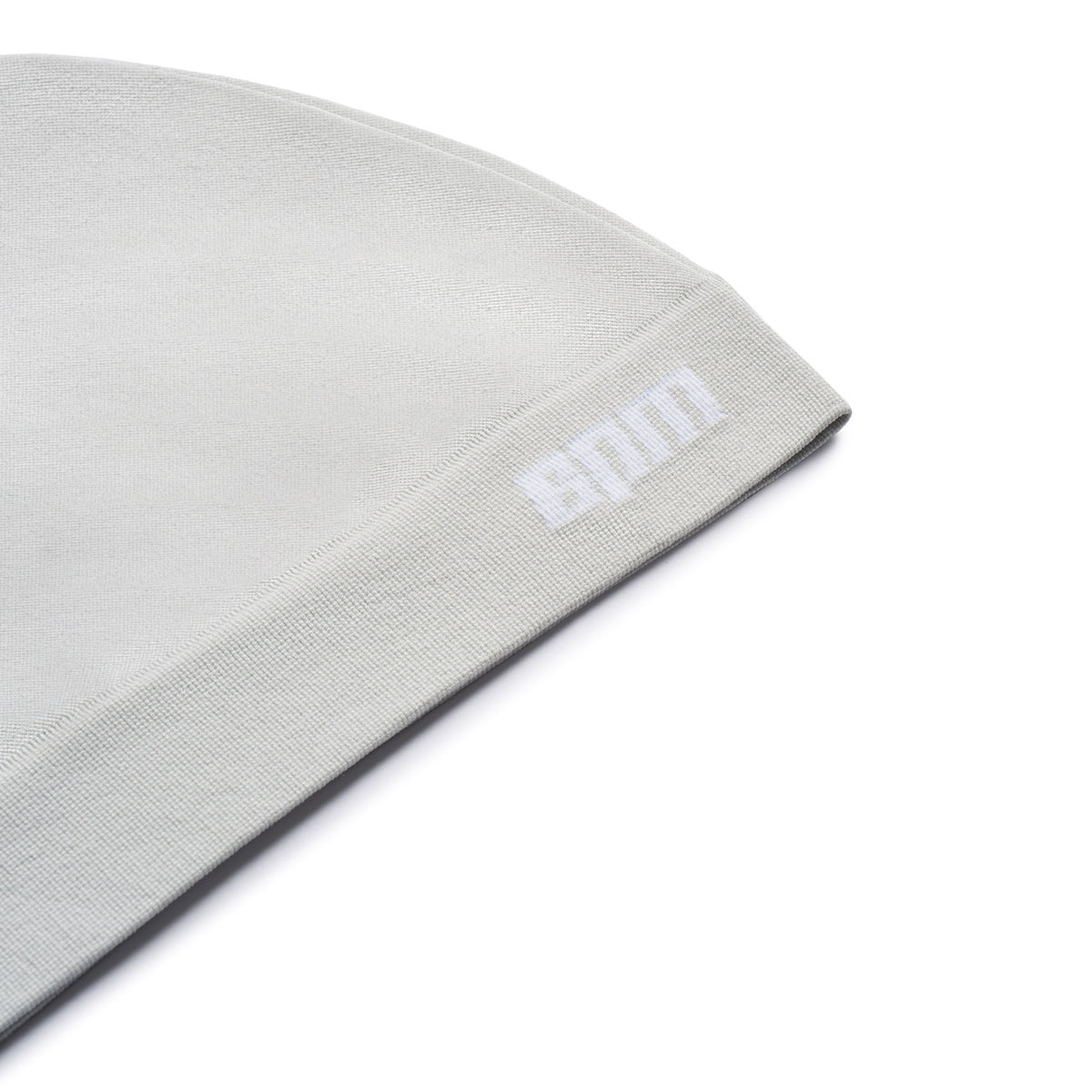 A close-up of the 6PM TECHNICAL LOGO BEANIE in Smoke Grey, featuring a folded brim and a small white logo near the edge, set against a white background.