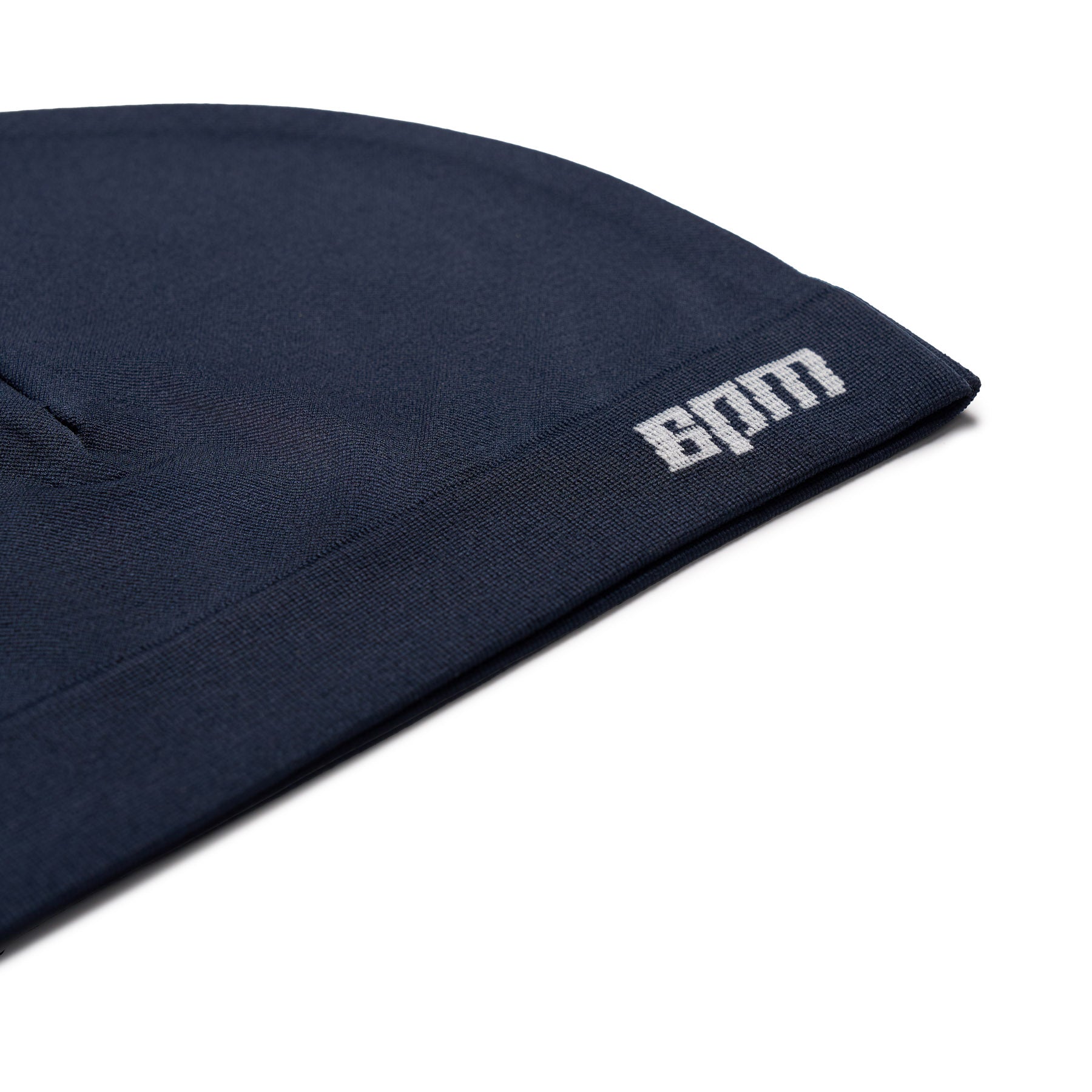 A close-up of the 6PM TECHNICAL LOGO BEANIE NAVY, featuring white BAM text on the folded brim, photographed against a white background.