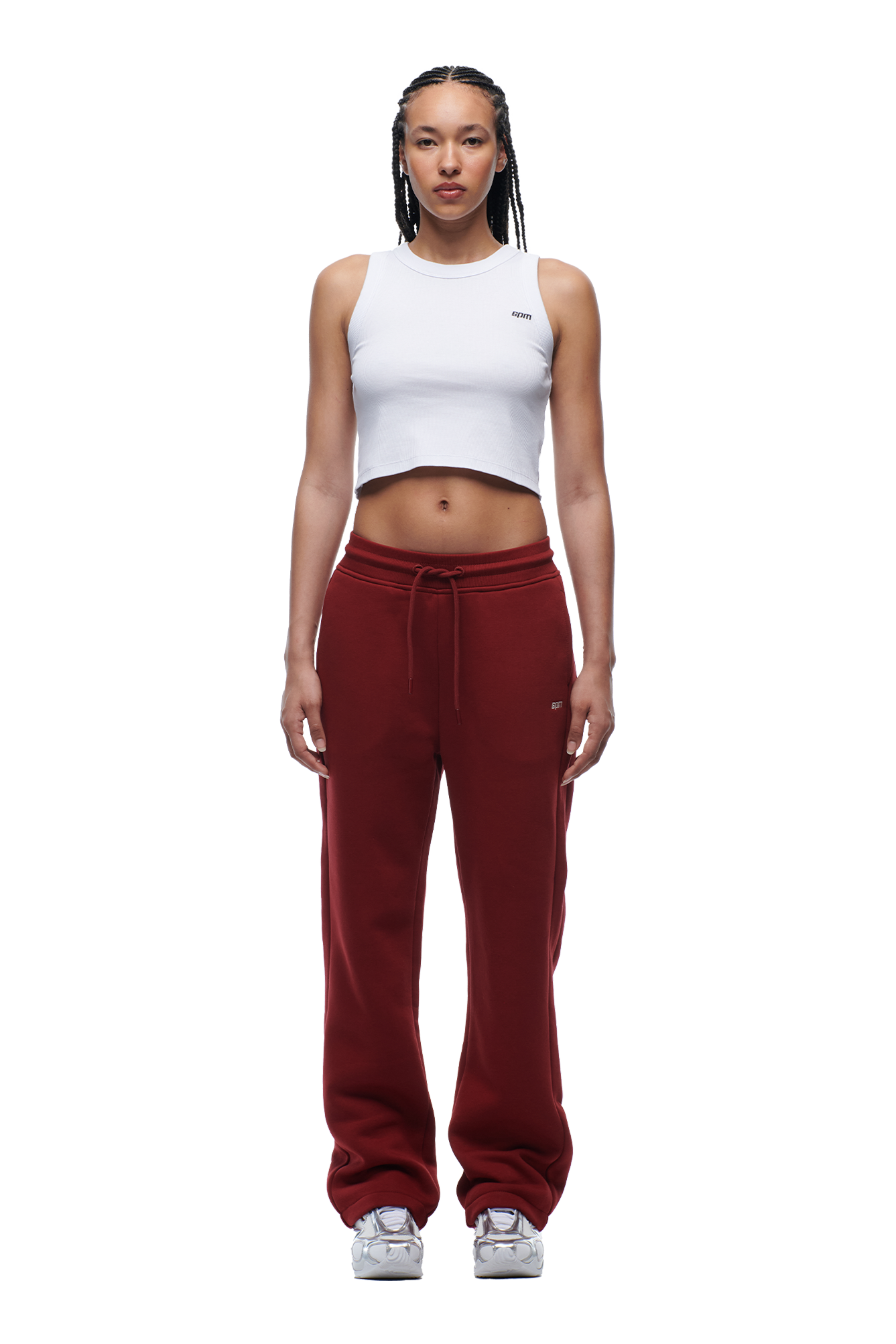 A woman with braided hair wears the 6PM WMNS OPEN LEG WINE RED sweatpants, styled with a white crop top and sneakers. She stands facing forward against a plain white background.