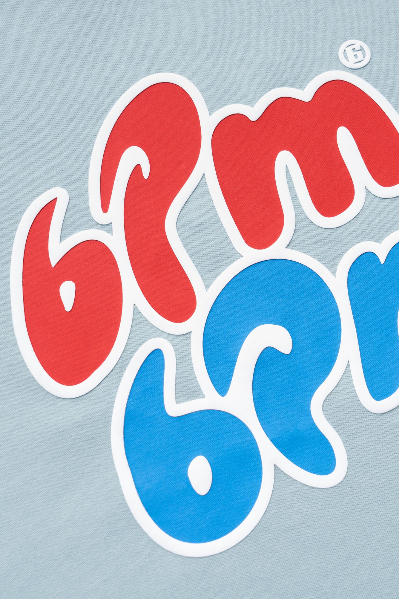 The ICE CREAM T-SHIRT BLUE by 6PM features a graphic design with bold red "6pm" and bold blue "6am" in a playful rounded font, set against a light gray background.