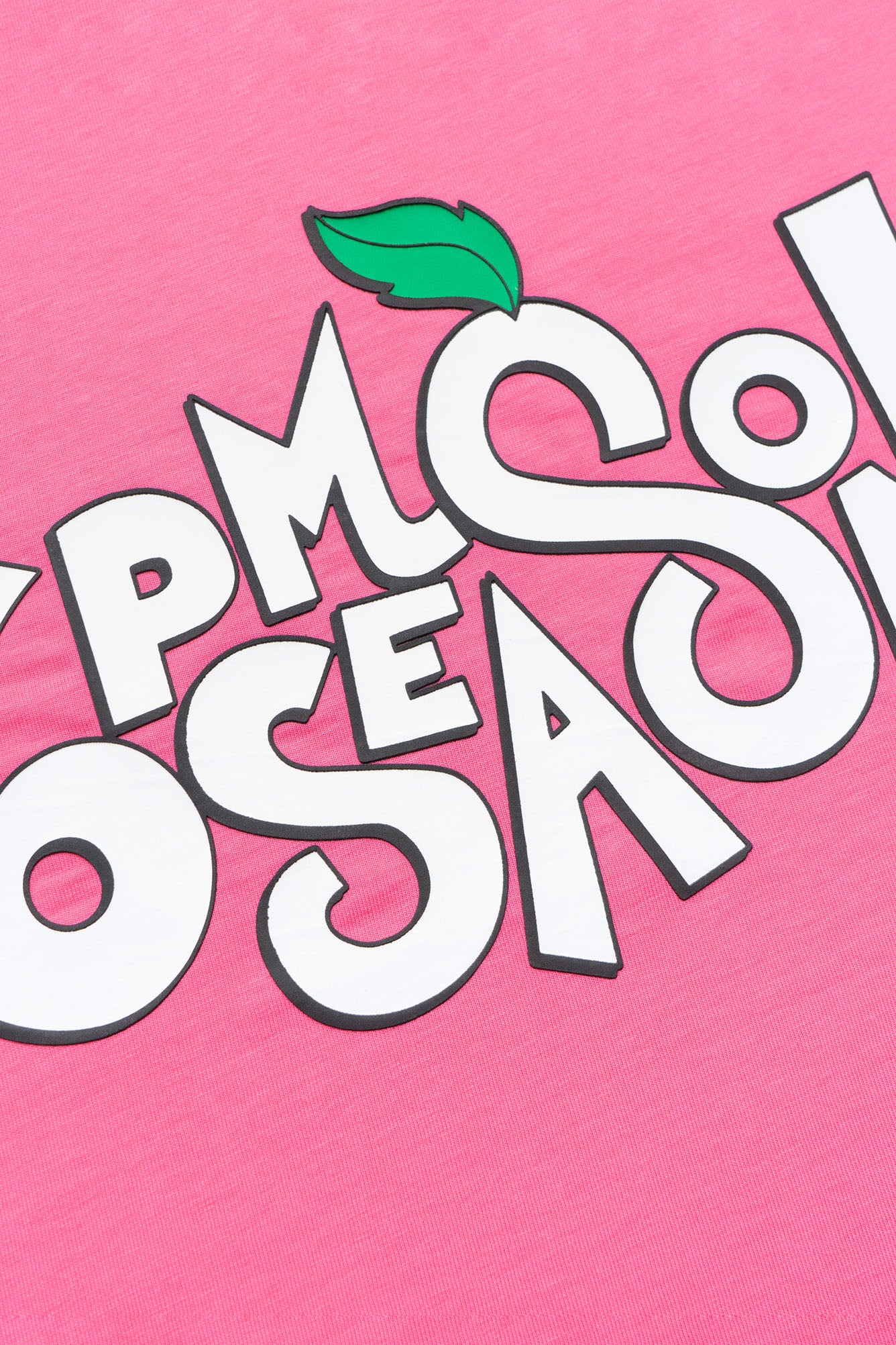 A close-up of the SODA PLAY T-SHIRT HOT PINK by 6PM shows bold, playful white letters with a small green leaf graphic above a “C”-shaped letter on bright pink fabric.
